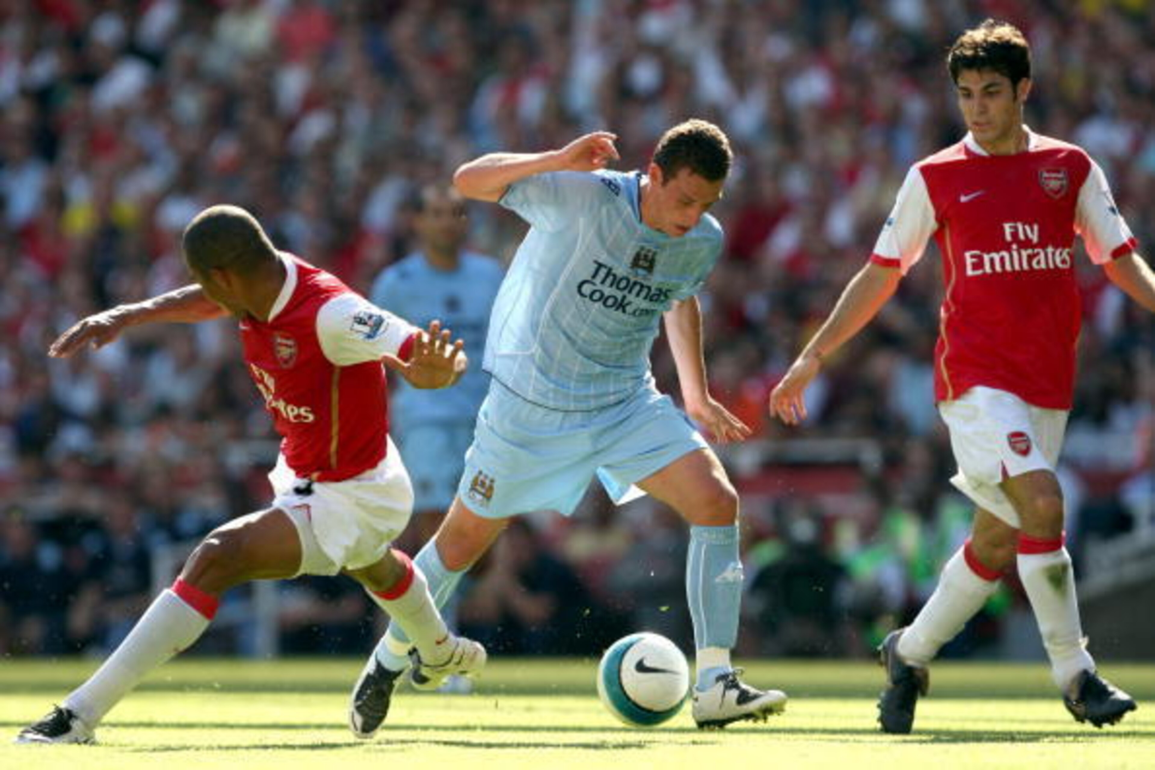 LONDON - AUGUST 25: Elano of Manchester City evades the tackle of Gilberto Silva of Arsenal as Cesc Fabregas looks on during the Barclays Premier League match between Arsenal and Manchester City at the Emirates Stadium on August 25, 2007 in London, Engla LONDON - AUGUST 25: Elano of Manchester City evades the tackle of Gilberto Silva of Arsenal as Cesc Fabregas looks on during the Barclays Premier League match between Arsenal and Manchester City at the Emirates Stadium on August 25, 2007 in London, Engla
