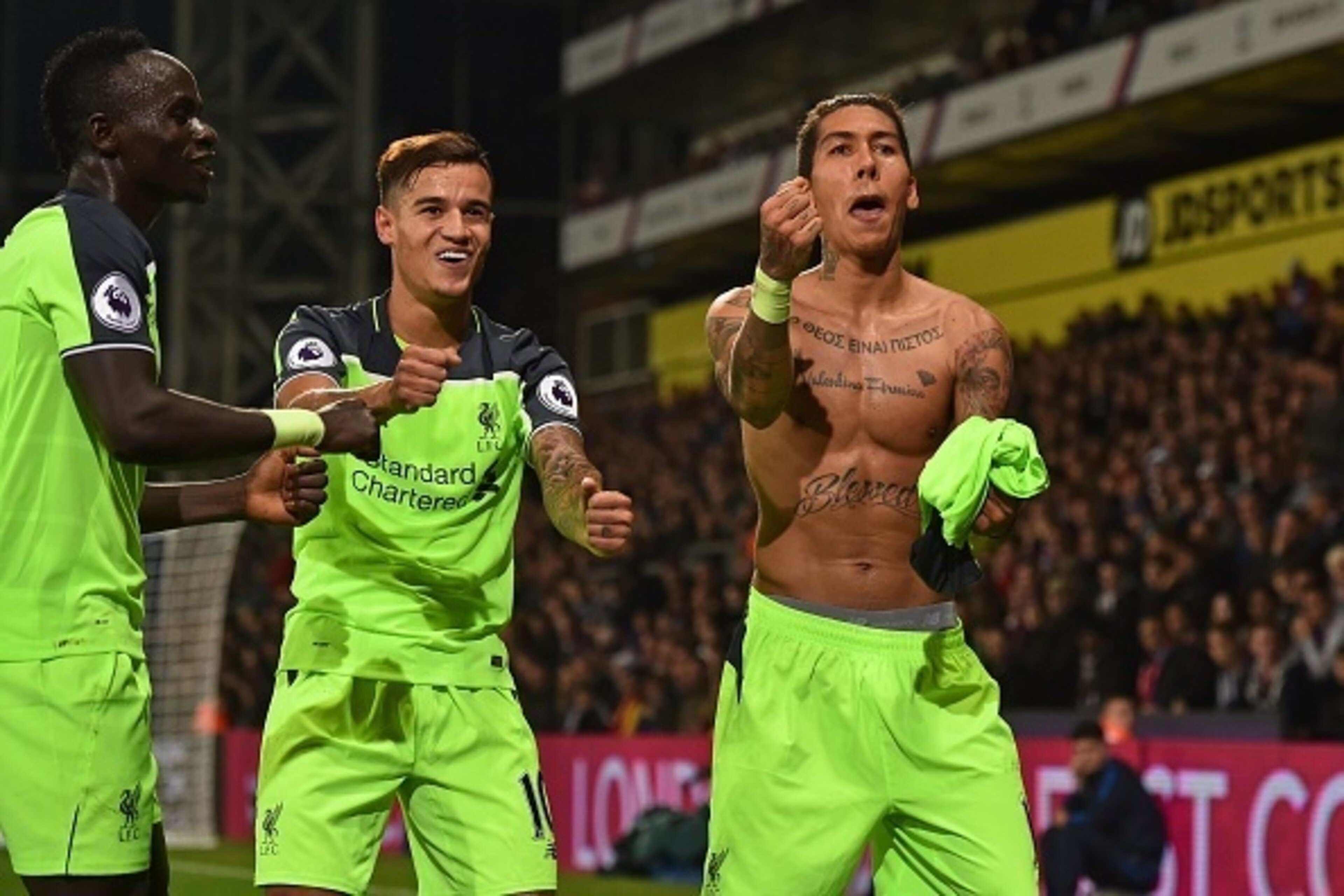 Liverpool's Brazilian midfielder Roberto Firmino (R) celebrates with Liverpool's Senegalese midfielder Sadio Mane (L) and Liverpool's Brazilian midfielder Philippe Coutinho after scoring their fourth goal during the English Premier League football match b