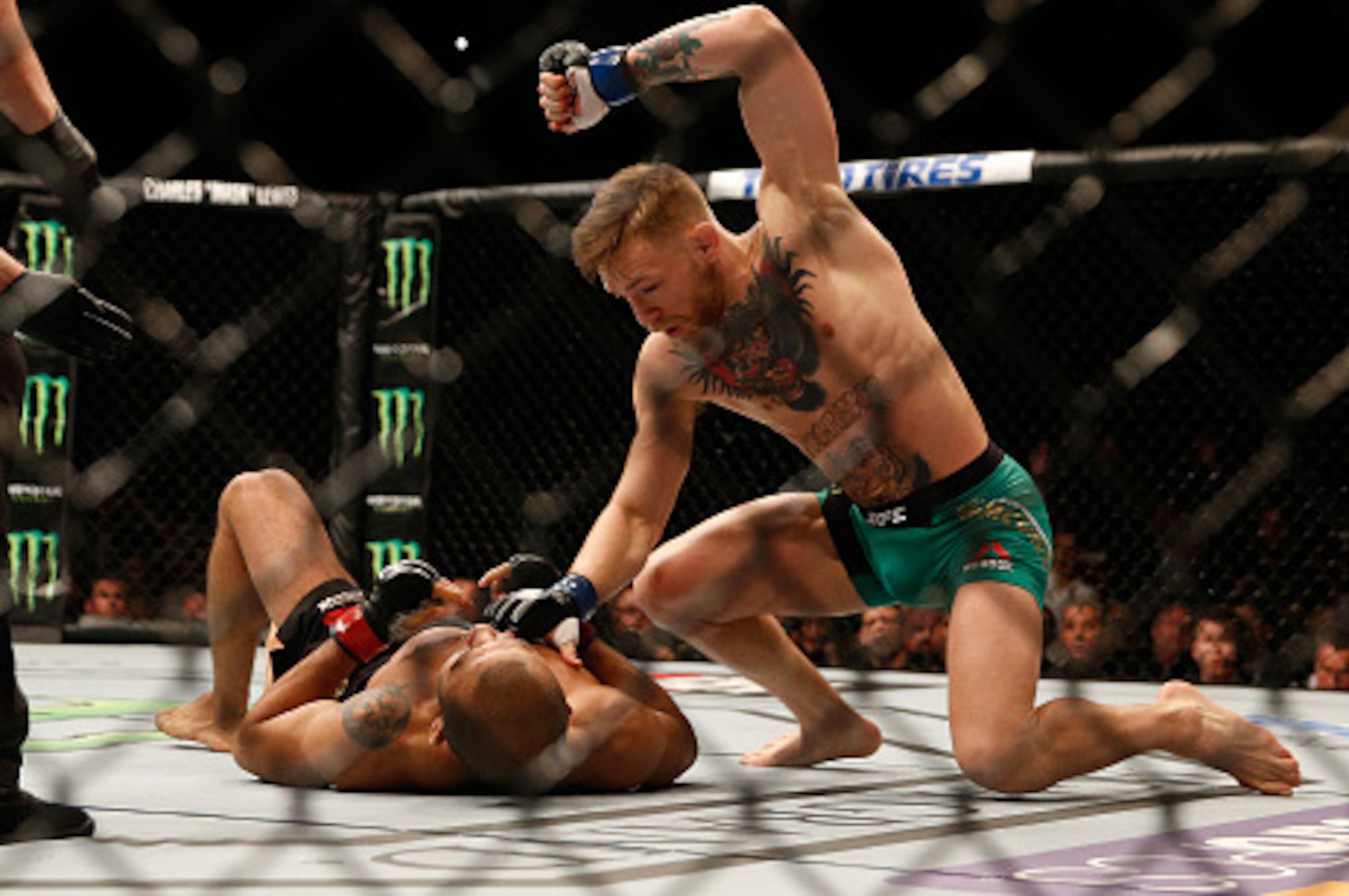 LAS VEGAS, NV - DECEMBER 12:  Conor McGregor of Ireland (top) punches Jose Aldo of Brazil in their UFC featherweight championship bout during the UFC 194 event inside MGM Grand Garden Arena on December 12, 2015 in Las Vegas, Nevada.  (Photo by Christian P