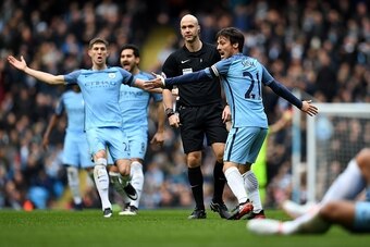 Manchester City's Spanish midfielder David Silva (R) and Manchester City's English defender John Stones (L) appeal to referee Anthony Taylor after Chelsea's Brazilian defender David Luiz (unseen) challenged Manchester City's Argentinian striker Sergio Agu