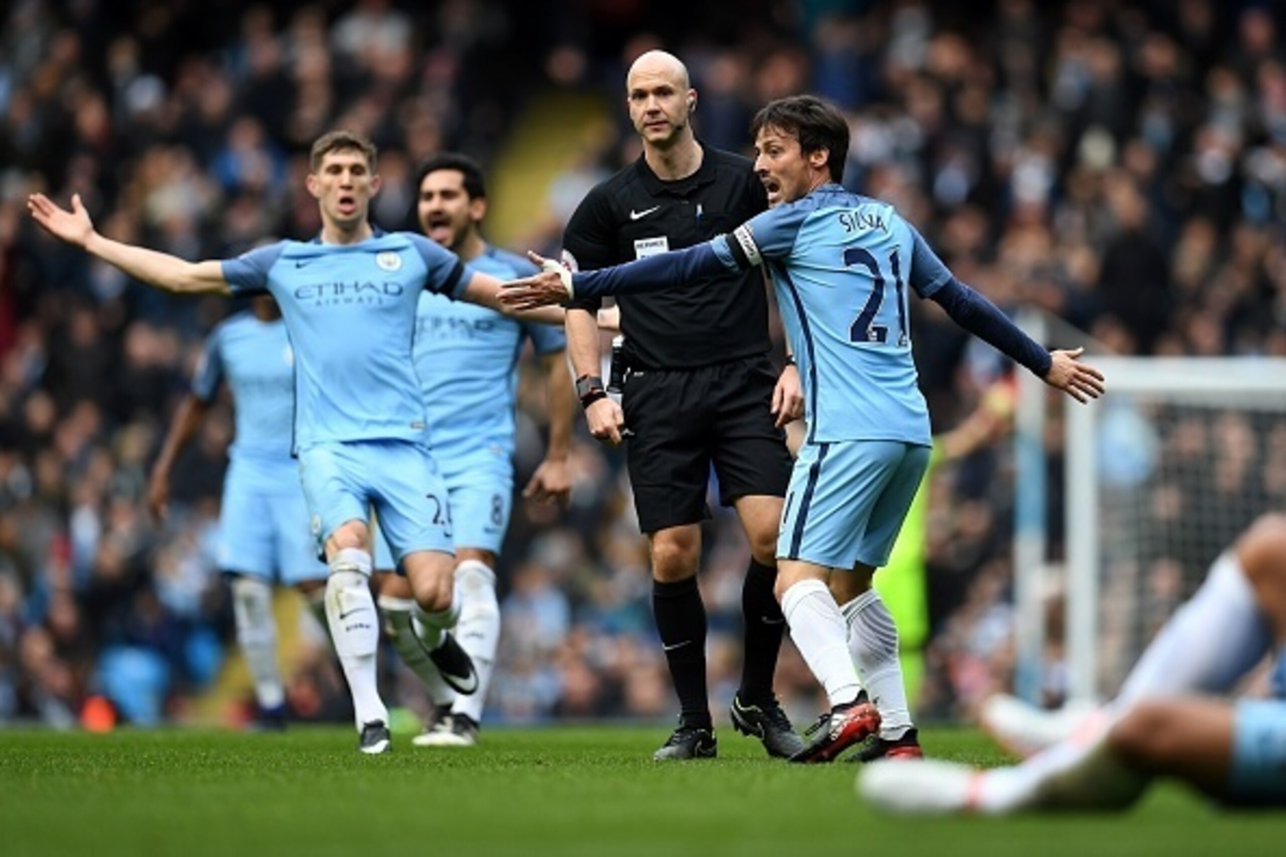 Manchester City's Spanish midfielder David Silva (R) and Manchester City's English defender John Stones (L) appeal to referee Anthony Taylor after Chelsea's Brazilian defender David Luiz (unseen) challenged Manchester City's Argentinian striker Sergio Agu Manchester City's Spanish midfielder David Silva (R) and Manchester City's English defender John Stones (L) appeal to referee Anthony Taylor after Chelsea's Brazilian defender David Luiz (unseen) challenged Manchester City's Argentinian striker Sergio Agu