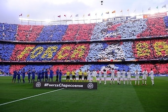 Barcelona and Real Madrid players applaud after observing a minute of silence to remember the victims of the Chapecoense football team before the Spanish league football match FC Barcelona vs Real Madrid CF at the Camp Nou stadium in Barcelona on December