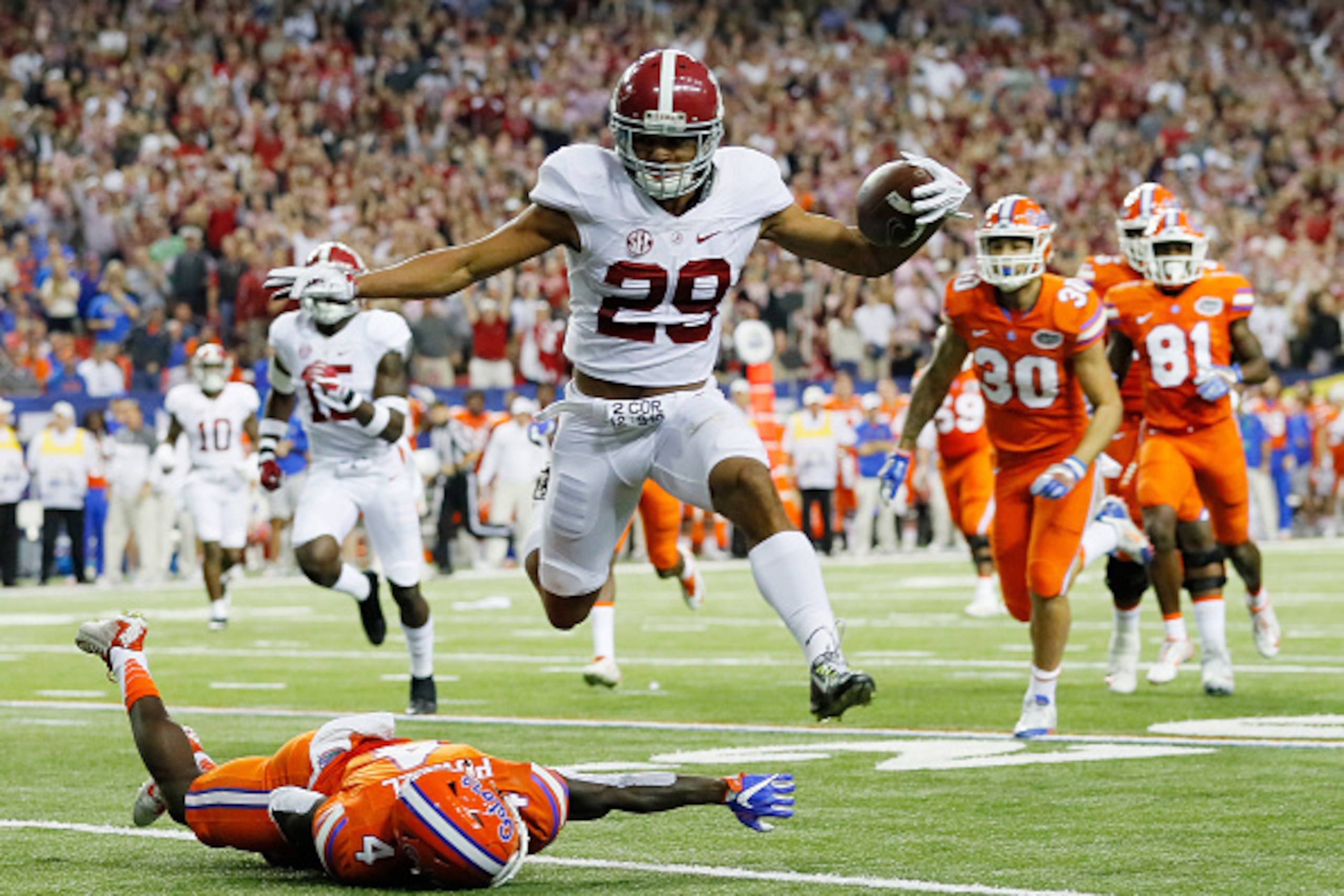 ATLANTA, GA - DECEMBER 03:  Minkah Fitzpatrick #29 of the Alabama Crimson Tide returns an interception for a touchdown as Brandon Powell #4 of the Florida Gators defends in the first quarter during the SEC Championship game at the Georgia Dome on December