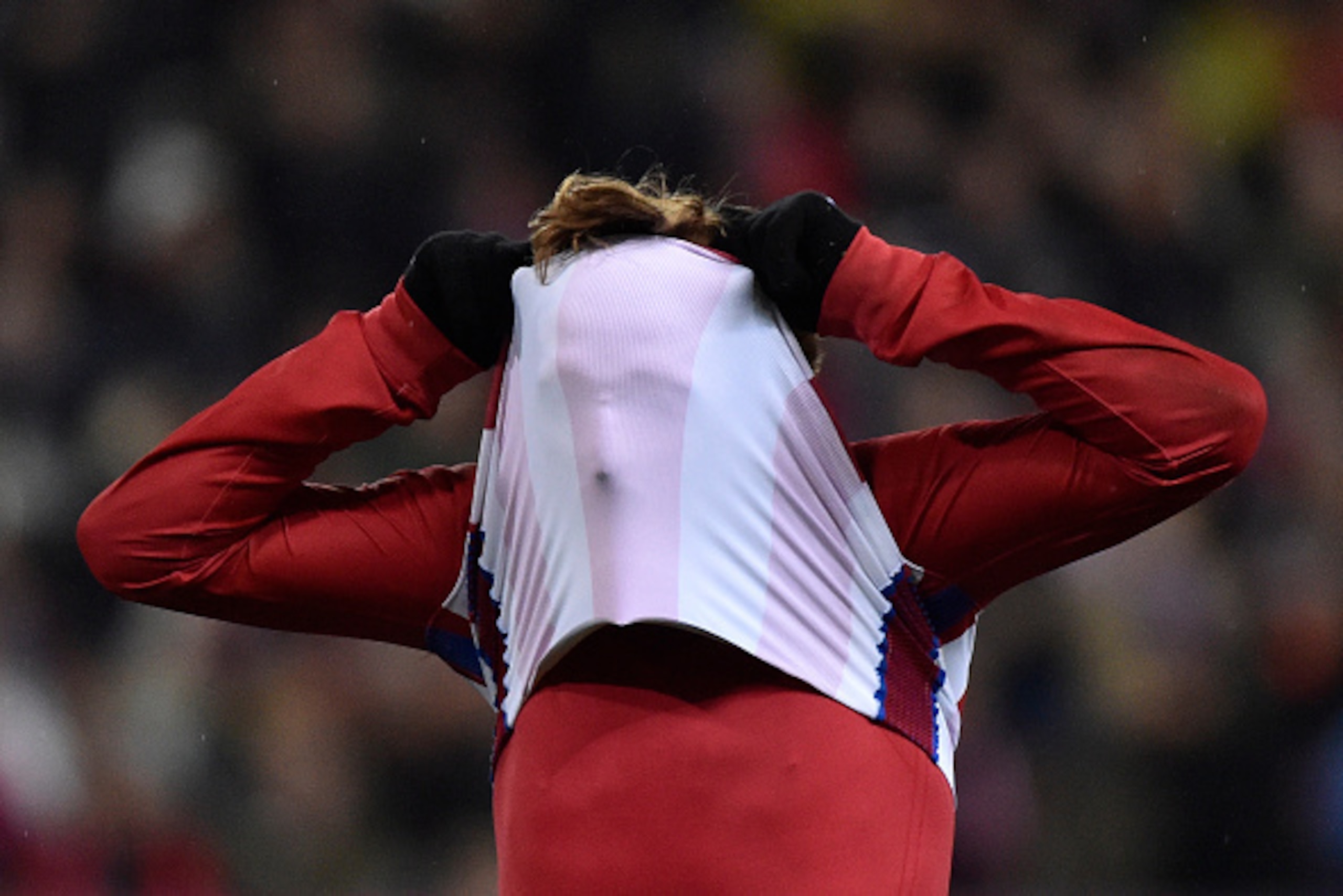 Atletico Madrid's French forward Antoine Griezmann covers his face with his jersey as he reacts after missing a goal opportunity during the Spanish league football match Club Atletico de Madrid vs RCD Espanyol at the Vicente Calderon stadium in Madrid on 