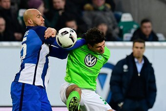 Hertha Berlin's US defender John Anthony Brooks (L) and Wolfsburg's German forward Mario Gomez vie for the ball during the German first division Bundesliga football match between VfL Wolfsburg and Hertha Berlin, at the Volkswagen-Arena in Wolfsburg, centr