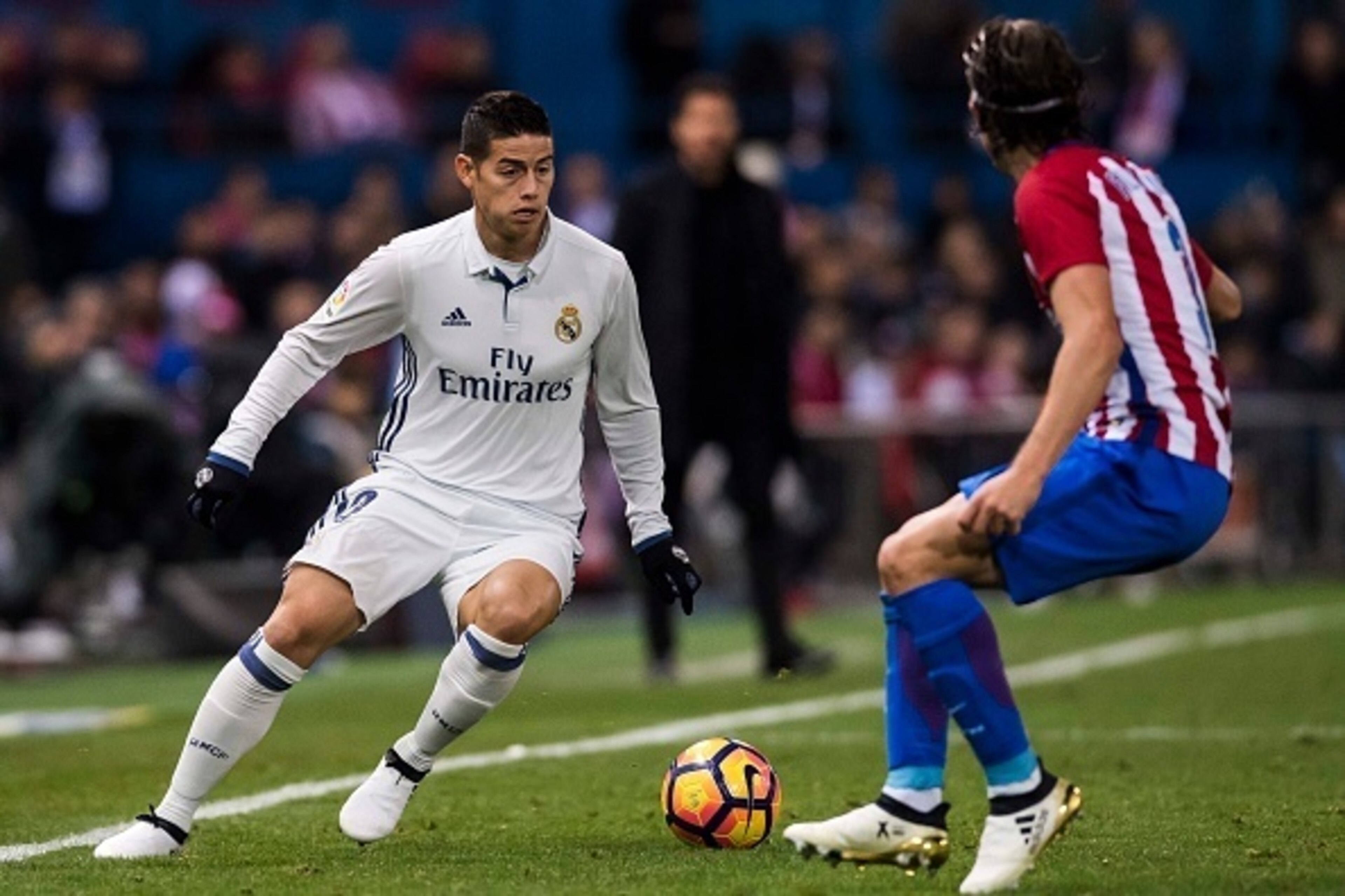 MADRID, SPAIN - NOVEMBER  19: James Rodriguez of Real Madrid fights for the ball with Filipe Luis of Atletico de Madrid during their La Liga match between Atletico de Madrid and Real Madrid at the Vicente Calderon Stadium on 19 November 2016 in Madrid, Sp
