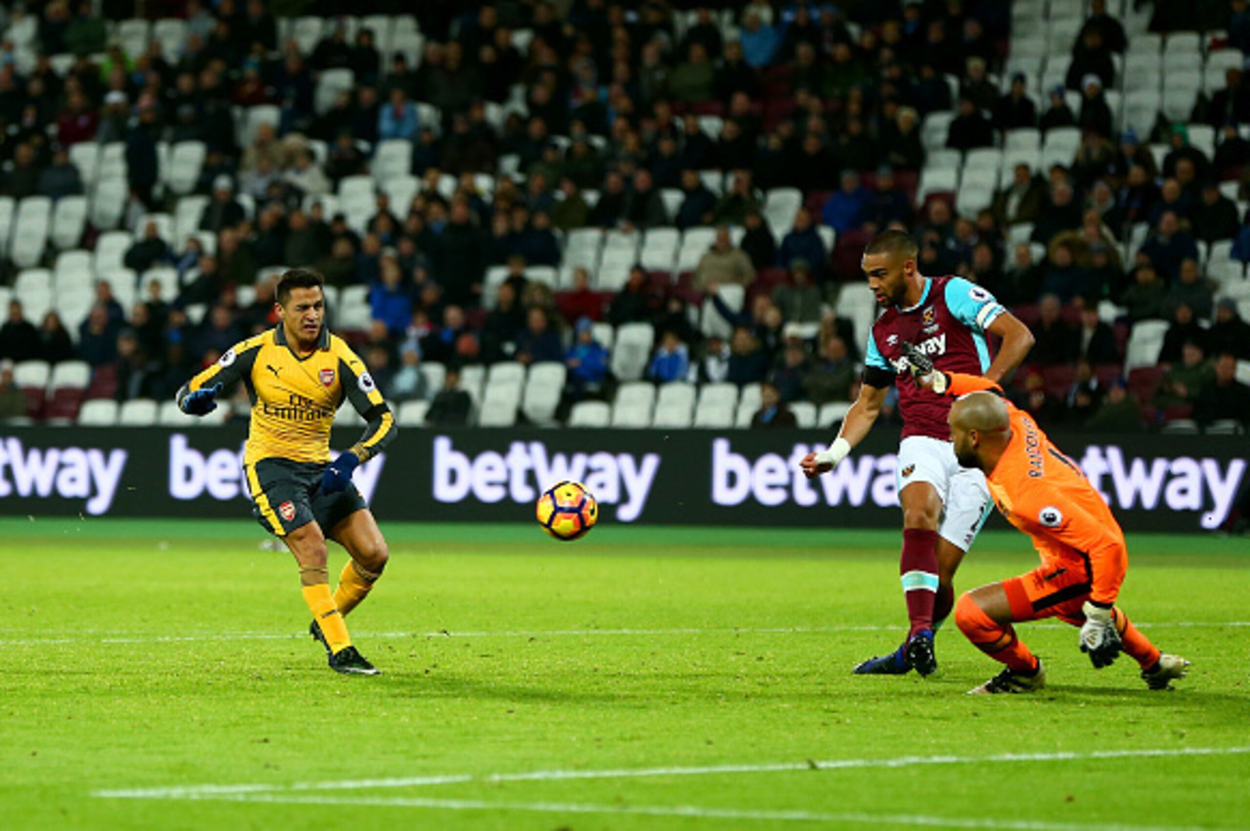 LONDON, ENGLAND - DECEMBER 03:  Alexis Sanchez of Arsenal beats goalkeeper Darren Randolph of West Ham United as he scores his team's fifth goal and completes his hat trick during the Premier League match between West Ham United and Arsenal at London Stad