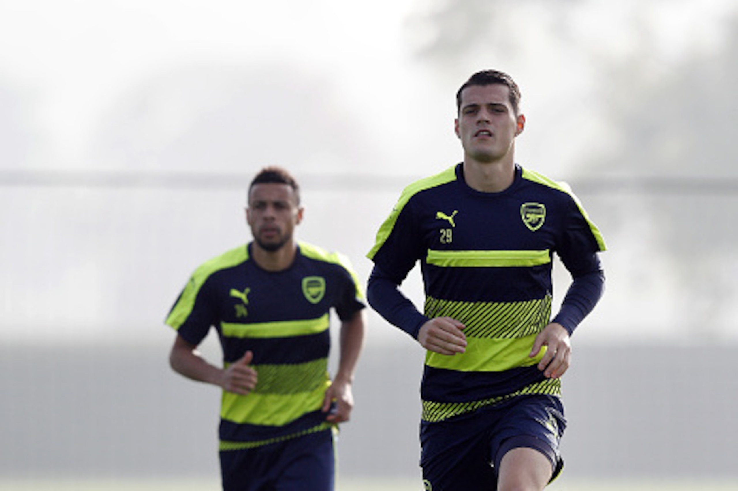 Arsenal's Swiss midfielder Granit Xhaka (R) and French midfielder Francis Coquelin (L) warm up during a training session at the club's complex in London Colney near Watford north of London on October 31, 2016 ahead of their UEFA Champions League group A f