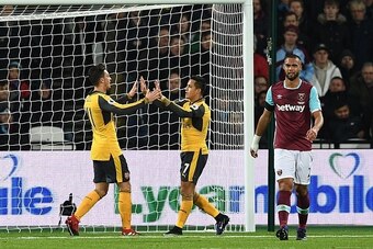 Arsenal's German midfielder Mesut Ozil (L) celebrates with Arsenal's Chilean striker Alexis Sanchez after scoring the opening goal of the English Premier League football match between West Ham United and Arsenal at The London Stadium, in east London on De