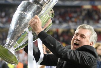 Real Madrid's Italian coach Carlo Ancelotti celebrates with the trophy at the end of the UEFA Champions League Final Real Madrid vs Atletico de Madrid at Luz stadium in Lisbon, on May 24, 2014. Real Madrid won 4-1.  AFP PHOTO/ MIGUEL RIOPA        (Photo c