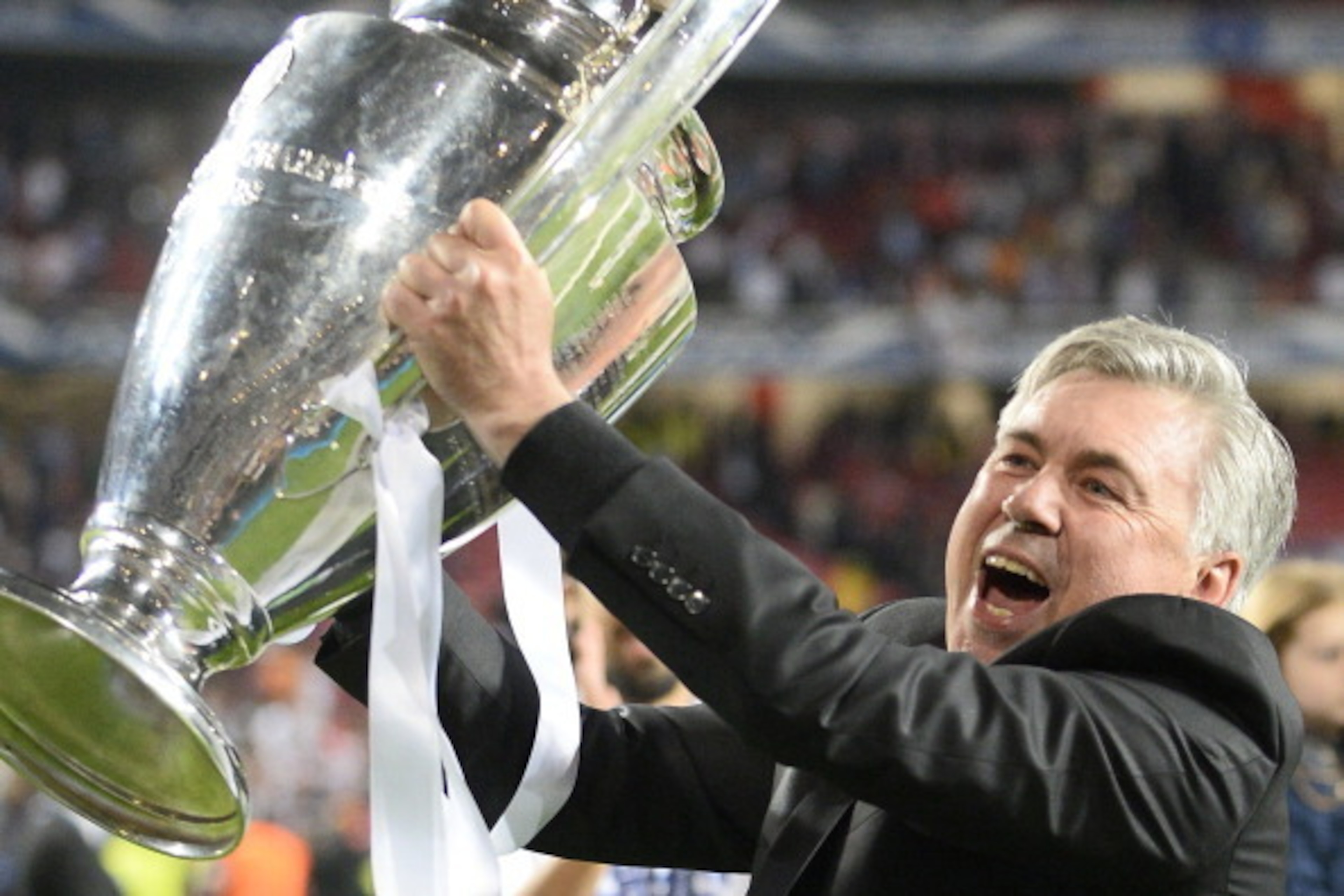 Real Madrid's Italian coach Carlo Ancelotti celebrates with the trophy at the end of the UEFA Champions League Final Real Madrid vs Atletico de Madrid at Luz stadium in Lisbon, on May 24, 2014. Real Madrid won 4-1. AFP PHOTO/ MIGUEL RIOPA (Photo c Real Madrid's Italian coach Carlo Ancelotti celebrates with the trophy at the end of the UEFA Champions League Final Real Madrid vs Atletico de Madrid at Luz stadium in Lisbon, on May 24, 2014. Real Madrid won 4-1. AFP PHOTO/ MIGUEL RIOPA (Photo c