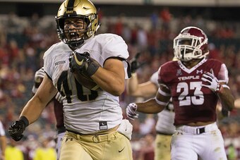 PHILADELPHIA, PA - SEPTEMBER 02: Andy Davidson #40 of the Army Black Knights run past Delvon Randall #23 of the Temple Owls to score a touchdown in the fourth quarter  at Lincoln Financial Field on September 2, 2016 in Philadelphia, Pennsylvania. The Blac