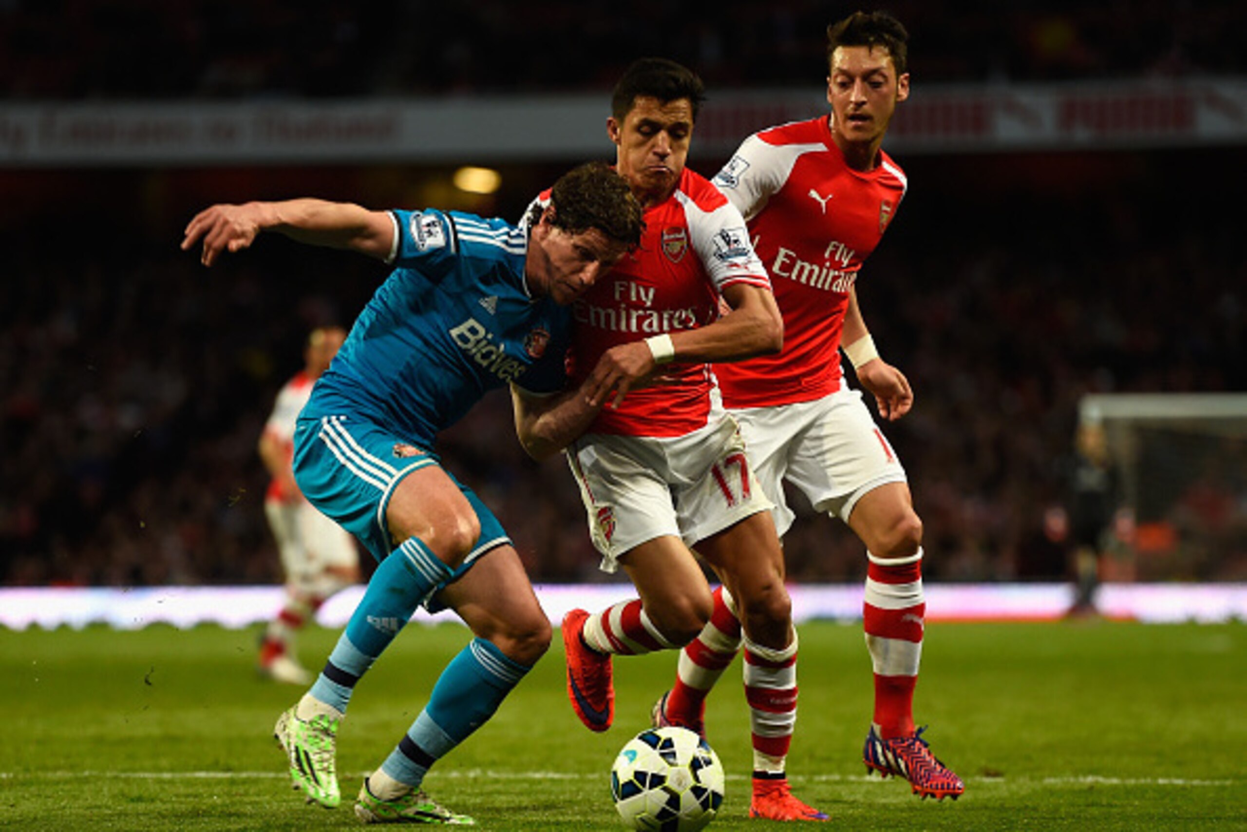 LONDON, ENGLAND - MAY 20: Billy Jones of Sunderland holds off Alexis Sanchez and Mesut Oezil of Arsenal during the Barclays Premier League match between Arsenal and Sunderland at Emirates Stadium on May 20, 2015 in London, England. (Photo by Mike Hewitt/ LONDON, ENGLAND - MAY 20: Billy Jones of Sunderland holds off Alexis Sanchez and Mesut Oezil of Arsenal during the Barclays Premier League match between Arsenal and Sunderland at Emirates Stadium on May 20, 2015 in London, England. (Photo by Mike Hewitt/