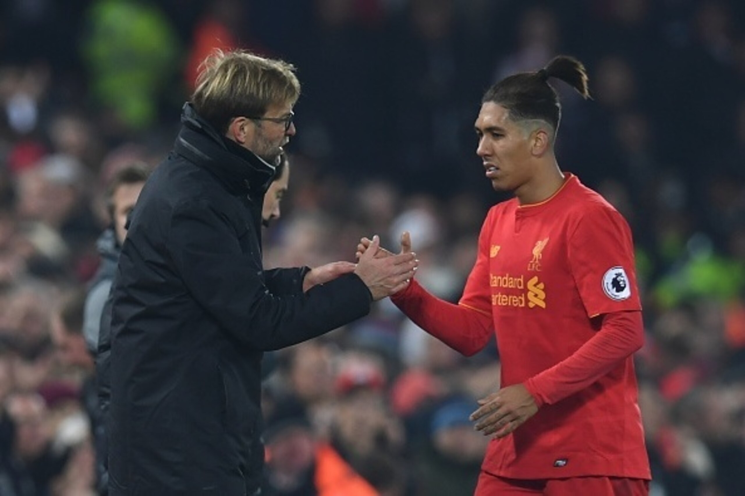 Liverpool's German manager Jurgen Klopp (L) shakes hands with Liverpool's Brazilian midfielder Roberto Firmino (R) as Firmino is substituted during the English Premier League football match between Liverpool and Sunderland at Anfield in Liverpool, north w