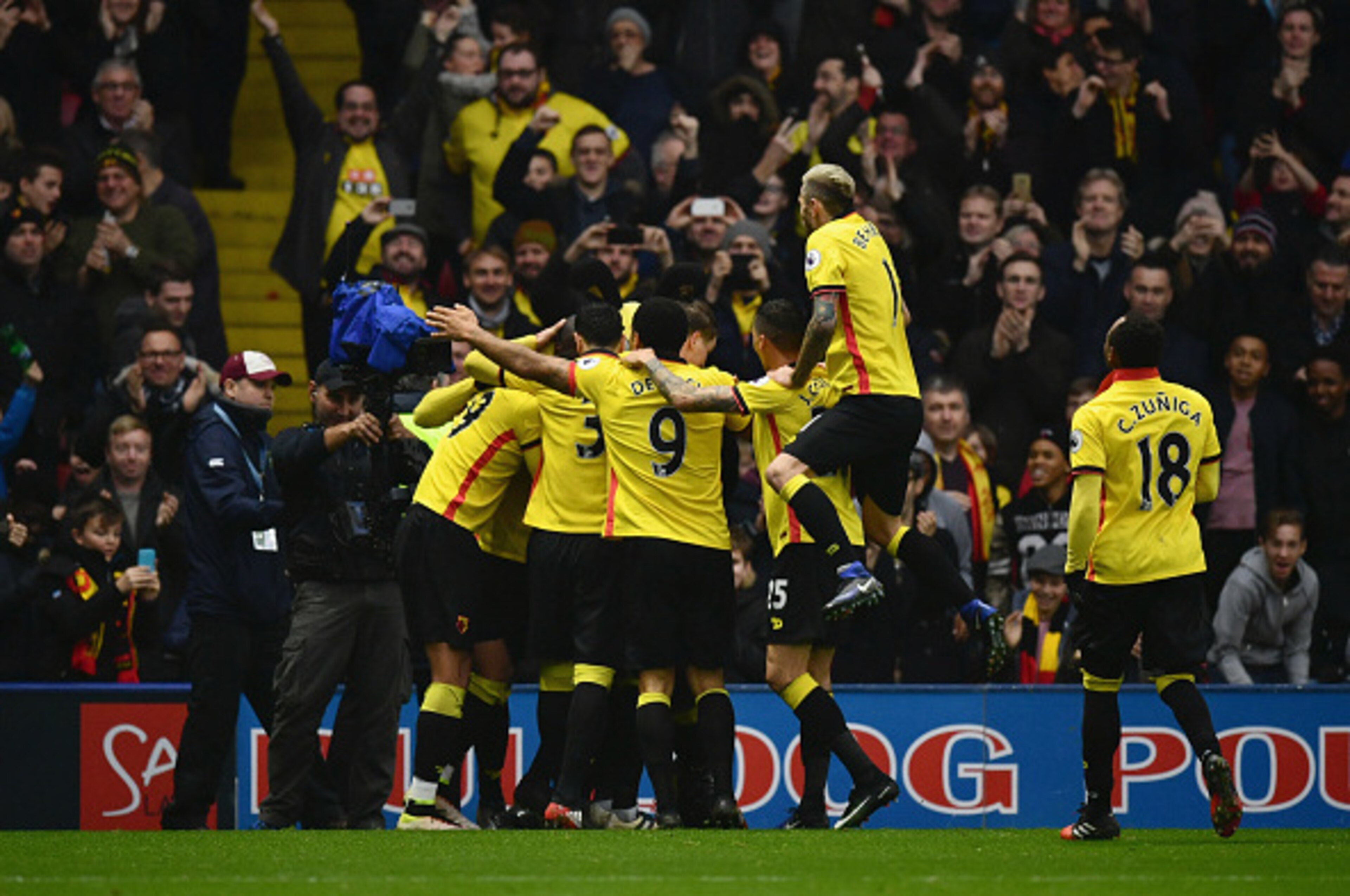 WATFORD, ENGLAND - DECEMBER 10:  Stefano Okaka of Watford (obscured) celebrates with team mates and fans as he scores their third goal during the Premier League match between Watford and Everton at Vicarage Road on December 10, 2016 in Watford, England.  