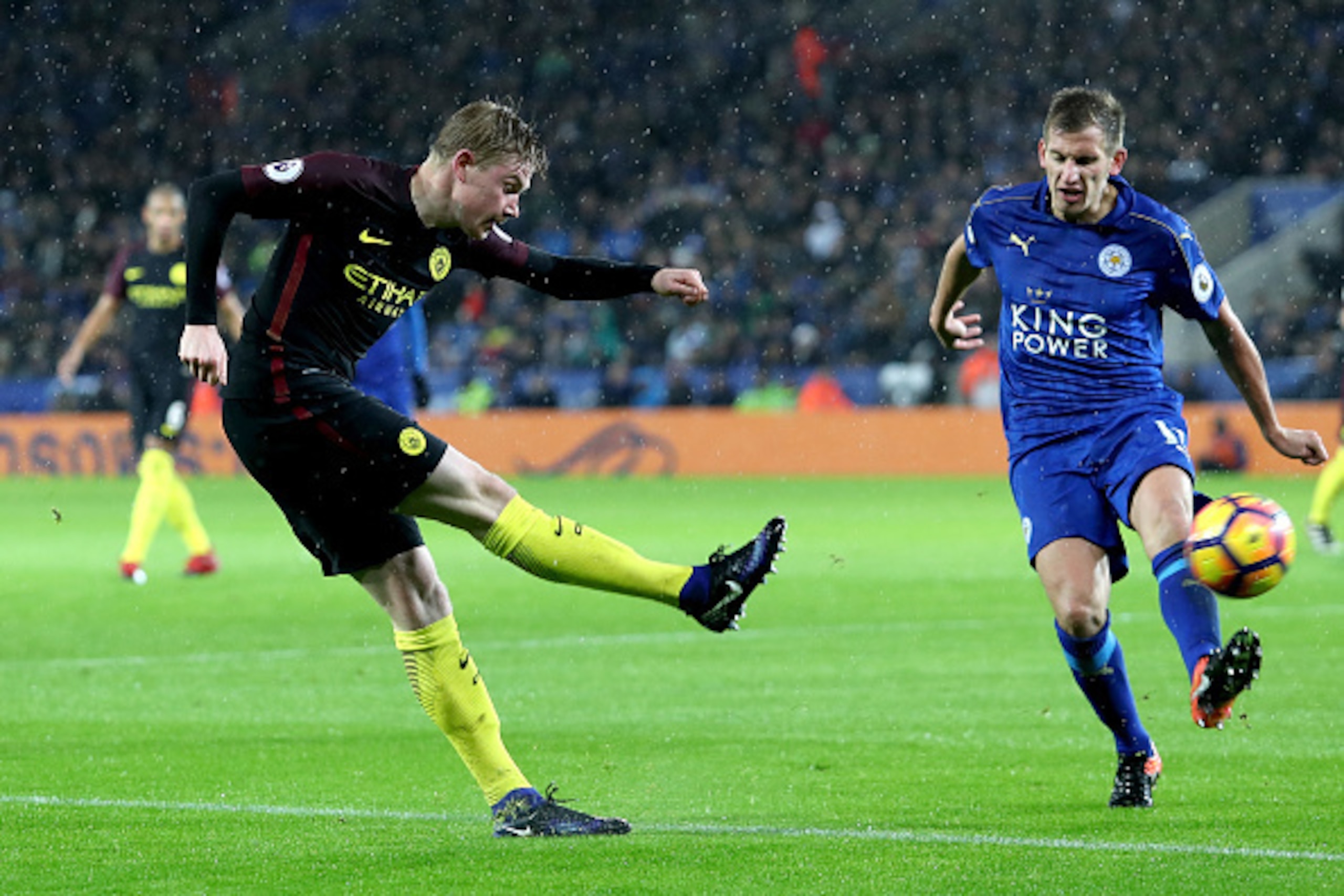 LEICESTER, ENGLAND - DECEMBER 10: Kevin De Bruyne of Manchester City (L) shoots while Marc Albrighton of Leicester City (R) attempts to block during the Premier League match between Leicester City and Manchester City at the King Power Stadium on December 