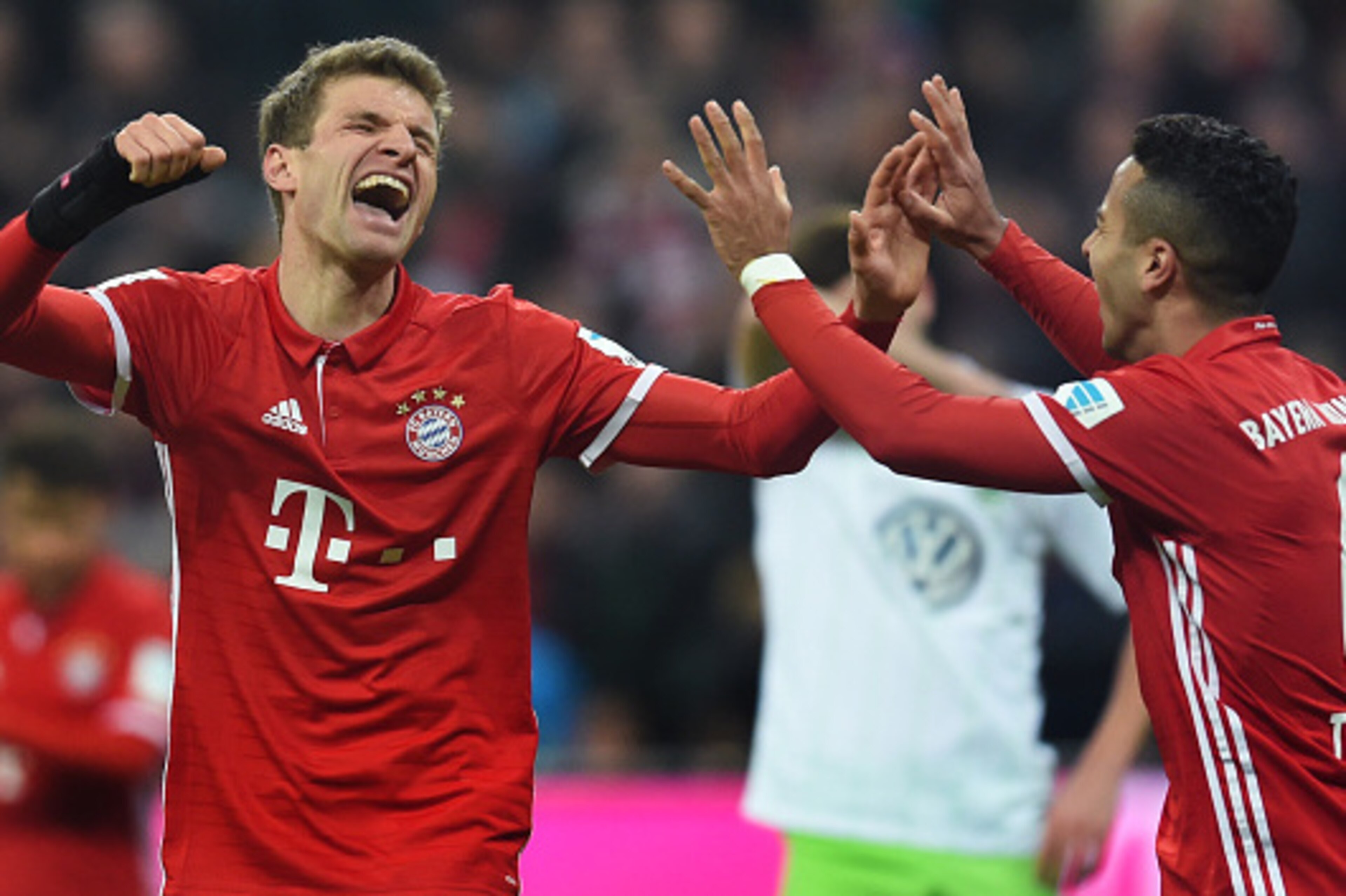 Bayern Munich's striker Thomas Mueller (L) and Bayern Munich's Spanish midfielder Thiago Alcantara (R) celebrate after the third goal for Munich during the German first division Bundesliga football match between FC Bayern Munich and Wolfsburg in Munich, s