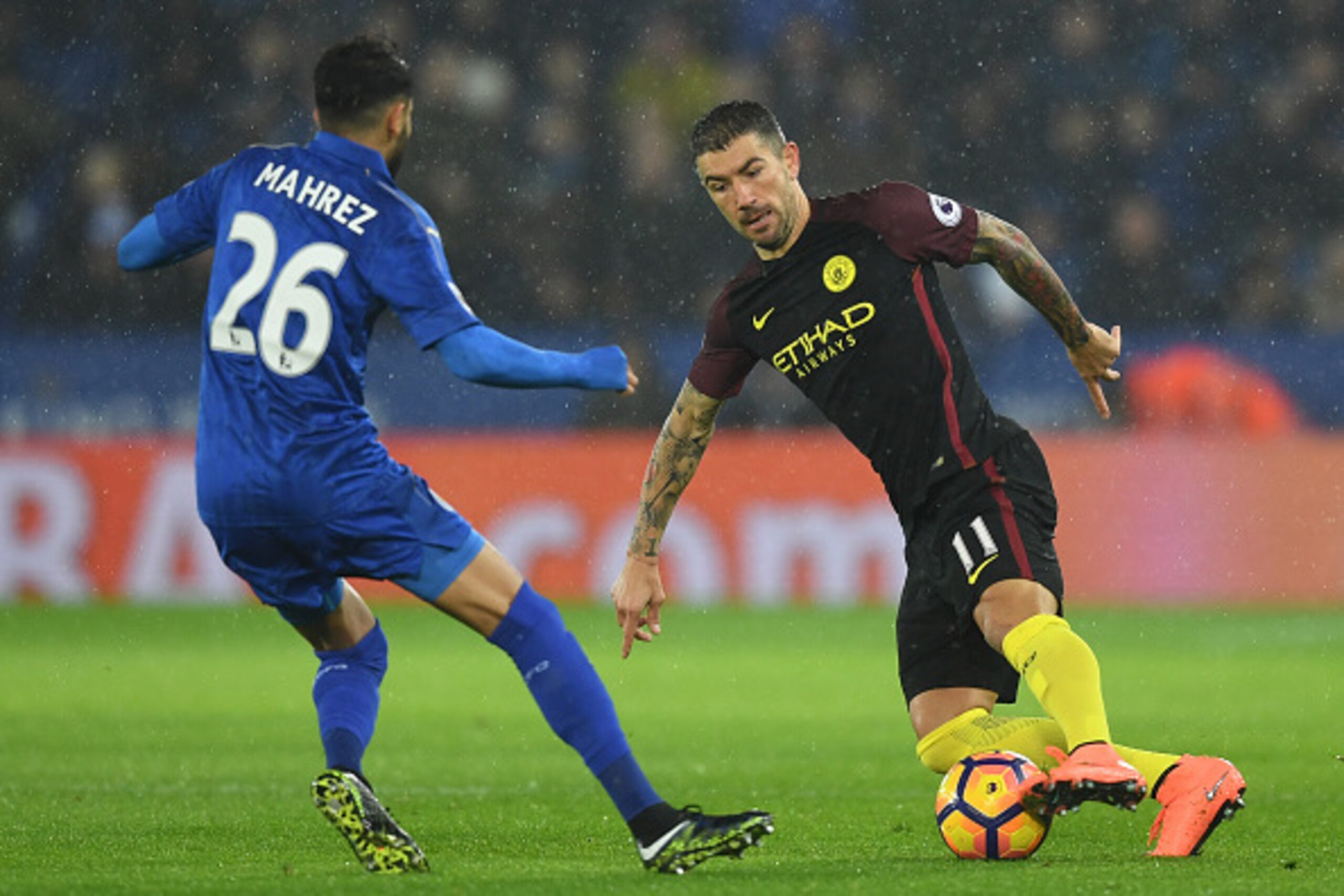 LEICESTER, ENGLAND - DECEMBER 10: Aleksander Kolorov of Manchester City (R) attempts to take the ball past Riyad Mahrez of Leicester City (L) during the Premier League match between Leicester City and Manchester City at the King Power Stadium on December LEICESTER, ENGLAND - DECEMBER 10: Aleksander Kolorov of Manchester City (R) attempts to take the ball past Riyad Mahrez of Leicester City (L) during the Premier League match between Leicester City and Manchester City at the King Power Stadium on December