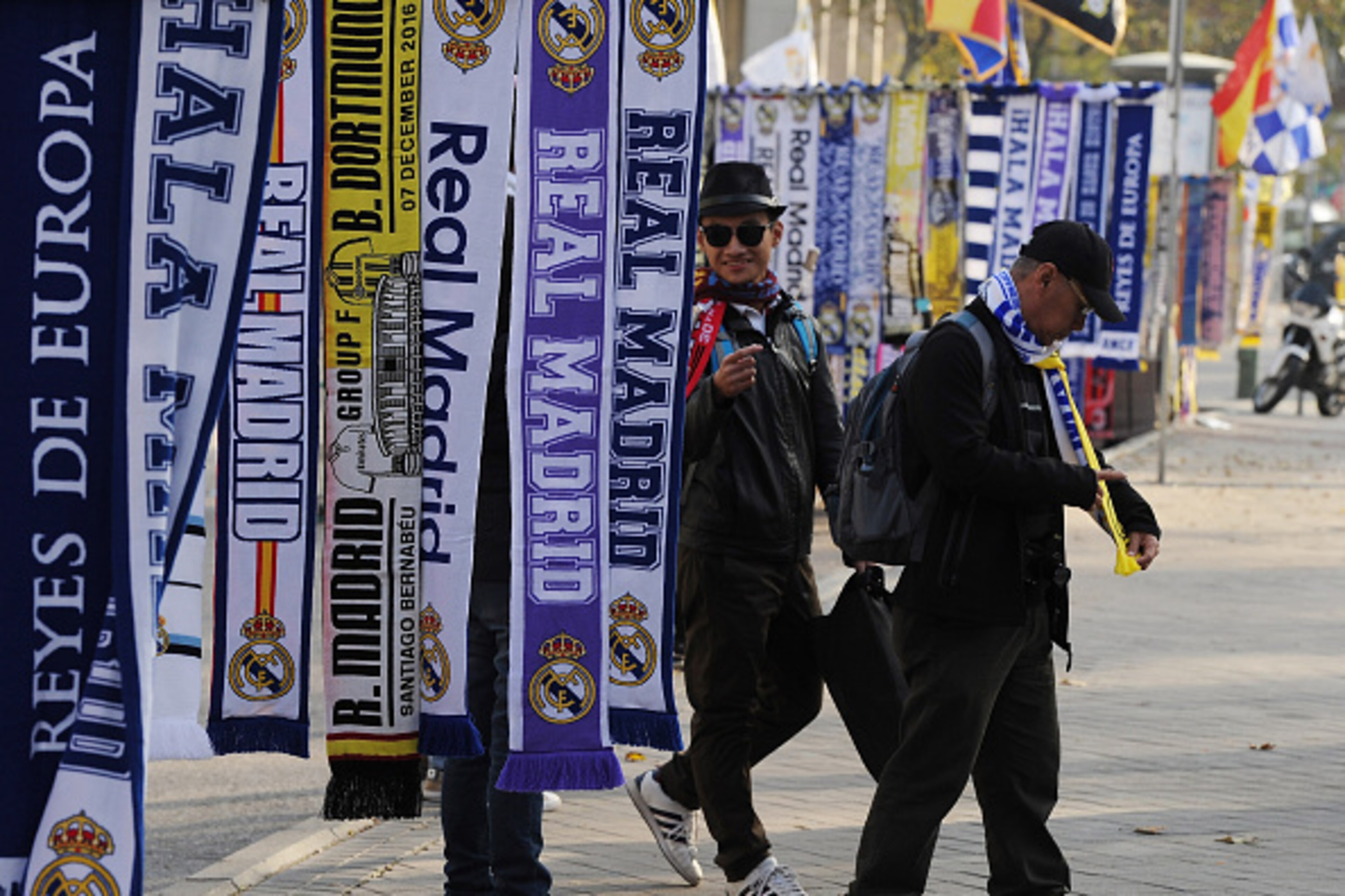MADRID, SPAIN - DECEMBER 07: Fans look at scarves for sale outside the Bernabeu stadium ahead of the UEFA Champions League match between Real Madrid CF and Borussia Dortmund at Bernabeu on December 7, 2016 in Madrid, Spain. (Photo by Denis Doyle/Getty I MADRID, SPAIN - DECEMBER 07: Fans look at scarves for sale outside the Bernabeu stadium ahead of the UEFA Champions League match between Real Madrid CF and Borussia Dortmund at Bernabeu on December 7, 2016 in Madrid, Spain. (Photo by Denis Doyle/Getty I