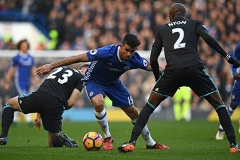 Chelsea's Brazilian-born Spanish striker Diego Costa (C) vies with West Bromwich Albion's Northern Irish defender Gareth McAuley (L) and West Bromwich Albion's French-born Cameroonian defender Allan Nyom (R) the English Premier League football match betwe