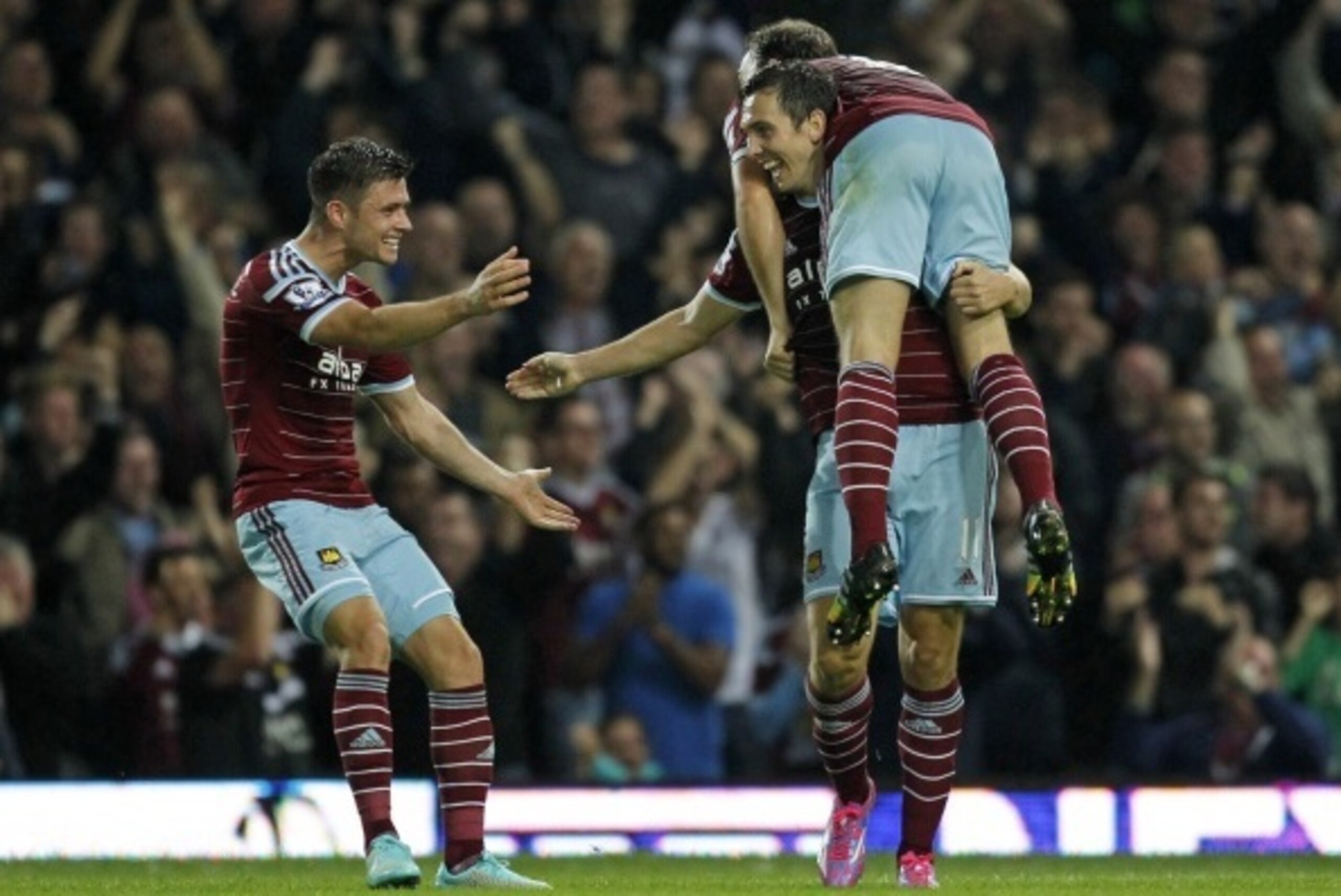 West Ham United's English defender Aaron Cresswell (L), West Ham United's English midfielder Stewart Downing and West Ham United's English midfielder Mark Noble (R) celebrate their third goal during the English Premier League football match between West H