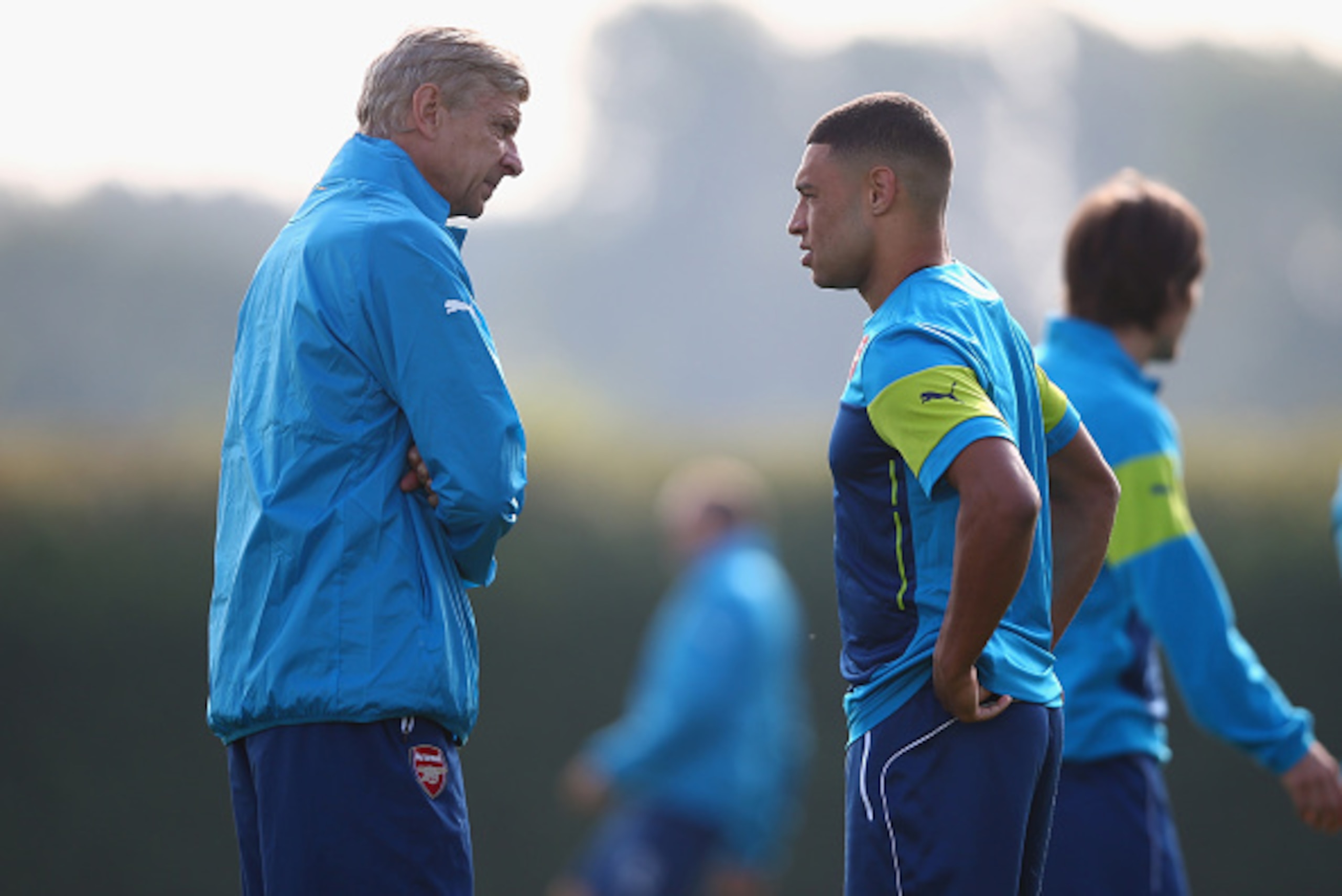 ST ALBANS, ENGLAND - SEPTEMBER 30:  Manager Arsene Wenger of Arsenal talks to Alex Oxlade-Chamberlain during an Arsenal training session ahead of their UEFA Champions League Group D match against Galatasaray at London Colney on September 30, 2014 in St Al