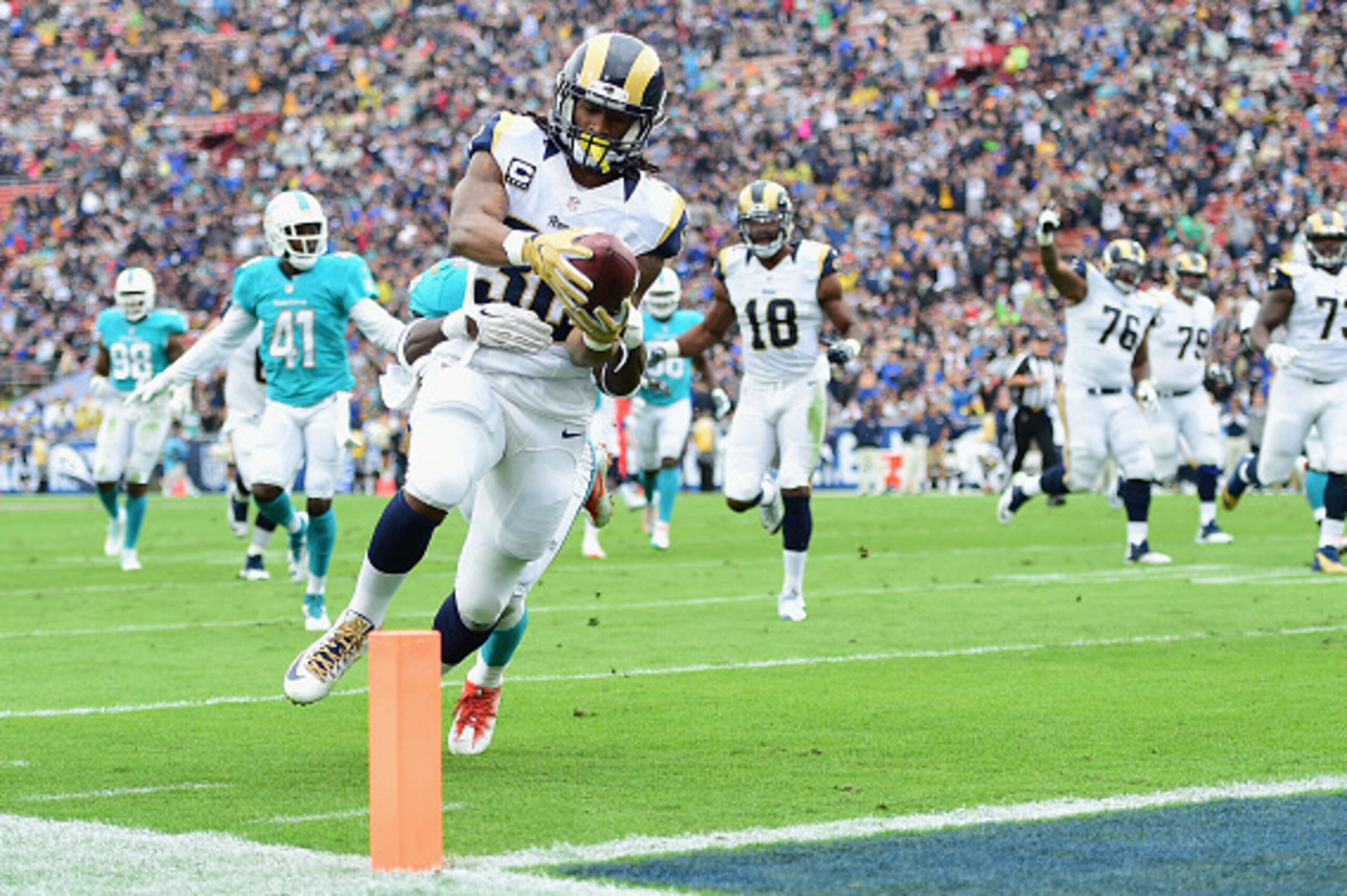 LOS ANGELES, CA - NOVEMBER 20:  Todd Gurley #30 of the Los Angeles Rams rushes for 24 yards to score a touchdown in front of Michael Thomas #31 of the Miami Dolphins in the first quarter of the game at Los Angeles Coliseum on November 20, 2016 in Los Ange