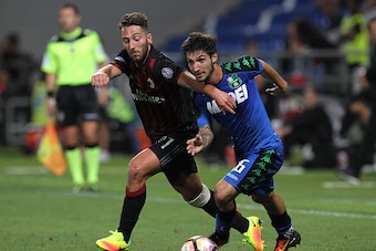 REGGIO NELL'EMILIA, ITALY - AUGUST 10:  Matteo Politano (R) of US Sassuolo Calcio is challenged by Andrea Bertolacci (L) of AC Milan during the TIM Preseason Tournament at Mapei Stadium - Citta' del Tricolore on August 10, 2016 in Reggio nell'Emilia, Ital
