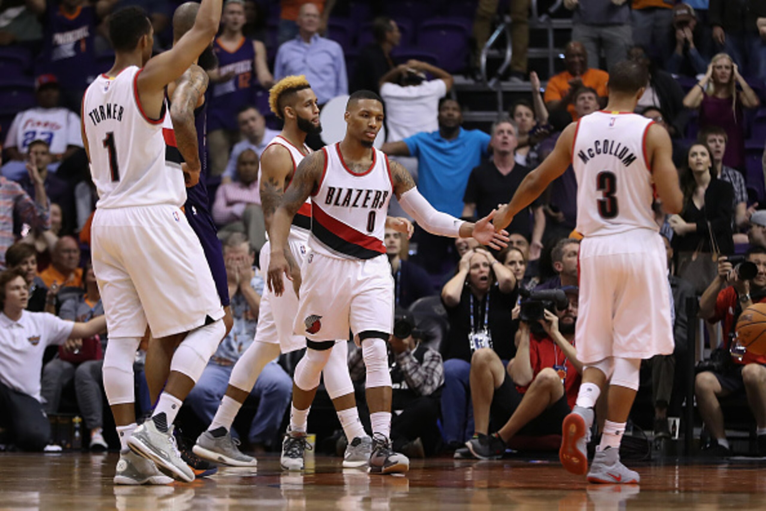 PHOENIX, AZ - NOVEMBER 02:  Damian Lillard #0 of the Portland Trail Blazers high fives C.J. McCollum and Evan Turner #1 after scoring against the Phoenix Suns during overtime of the NBA game at Talking Stick Resort Arena on November 2, 2016 in Phoenix, Ar