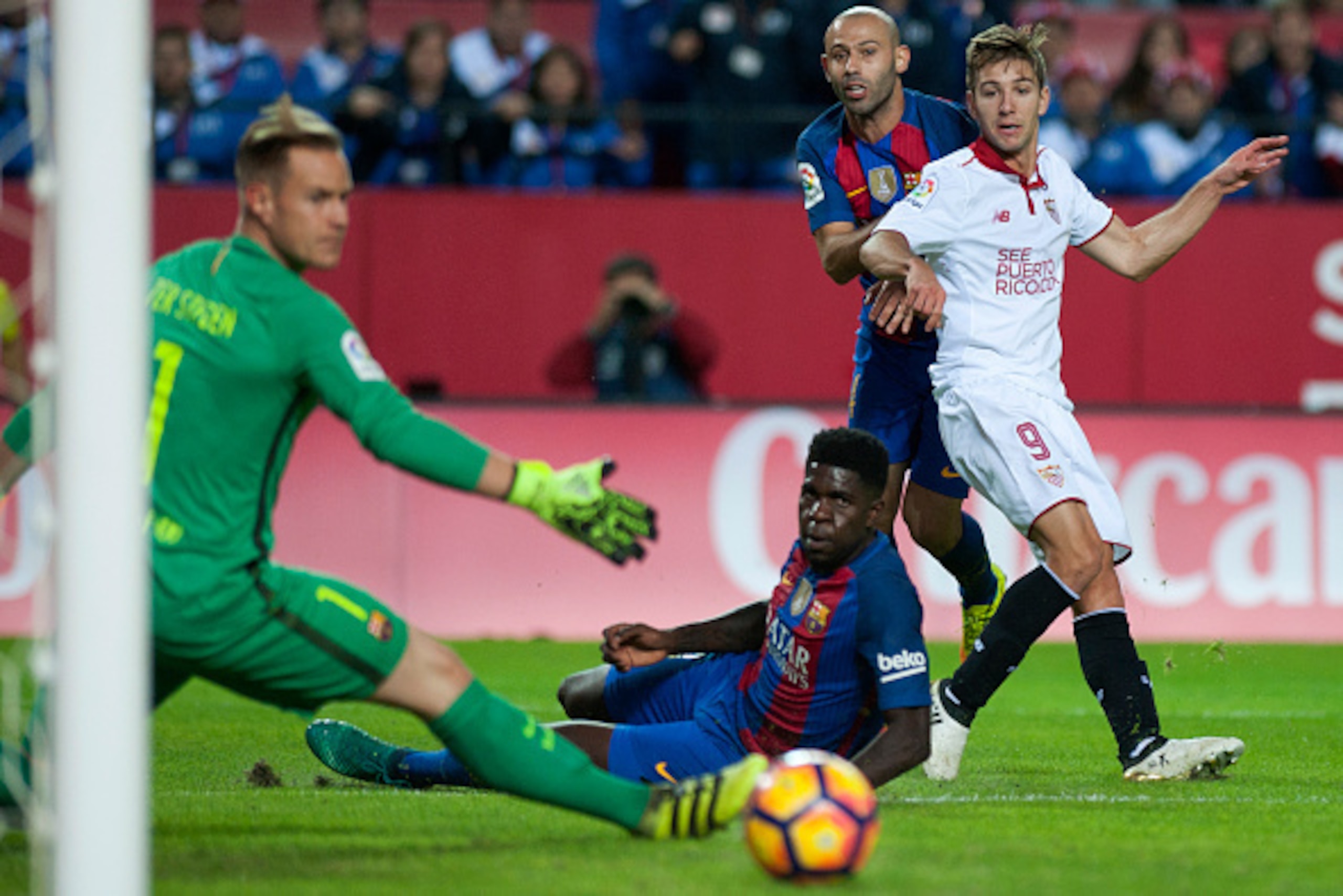 Sevilla's Argentinian forward Luciano Vietto (R) eyes the ball past (FromL) Barcelona's German goalkeeper Marc-Andre ter Stegen, Barcelona's French defender Samuel Umtiti and Barcelona's Argentinian midfielder Javier Mascherano during the Spanish league f