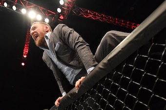 BELFAST, NORTHERN IRELAND - NOVEMBER 19:  UFC lightweight and featherweight champion Conor McGregor climbs into the Octagon to celebrate with teammate Artem Lobov after his featherweight bout against Teruto Ishihara during the UFC Fight Night at the SSE A