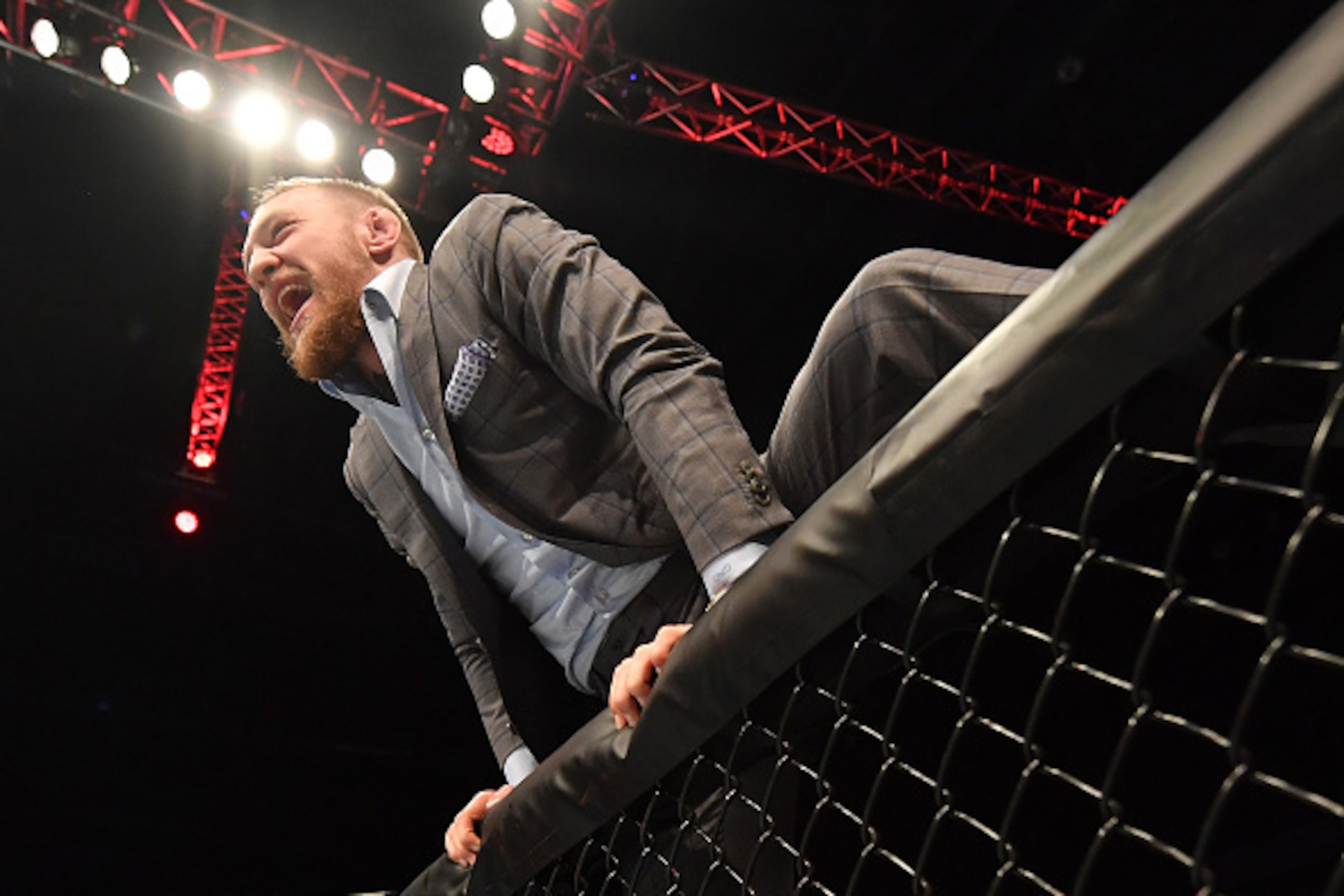 BELFAST, NORTHERN IRELAND - NOVEMBER 19:  UFC lightweight and featherweight champion Conor McGregor climbs into the Octagon to celebrate with teammate Artem Lobov after his featherweight bout against Teruto Ishihara during the UFC Fight Night at the SSE A