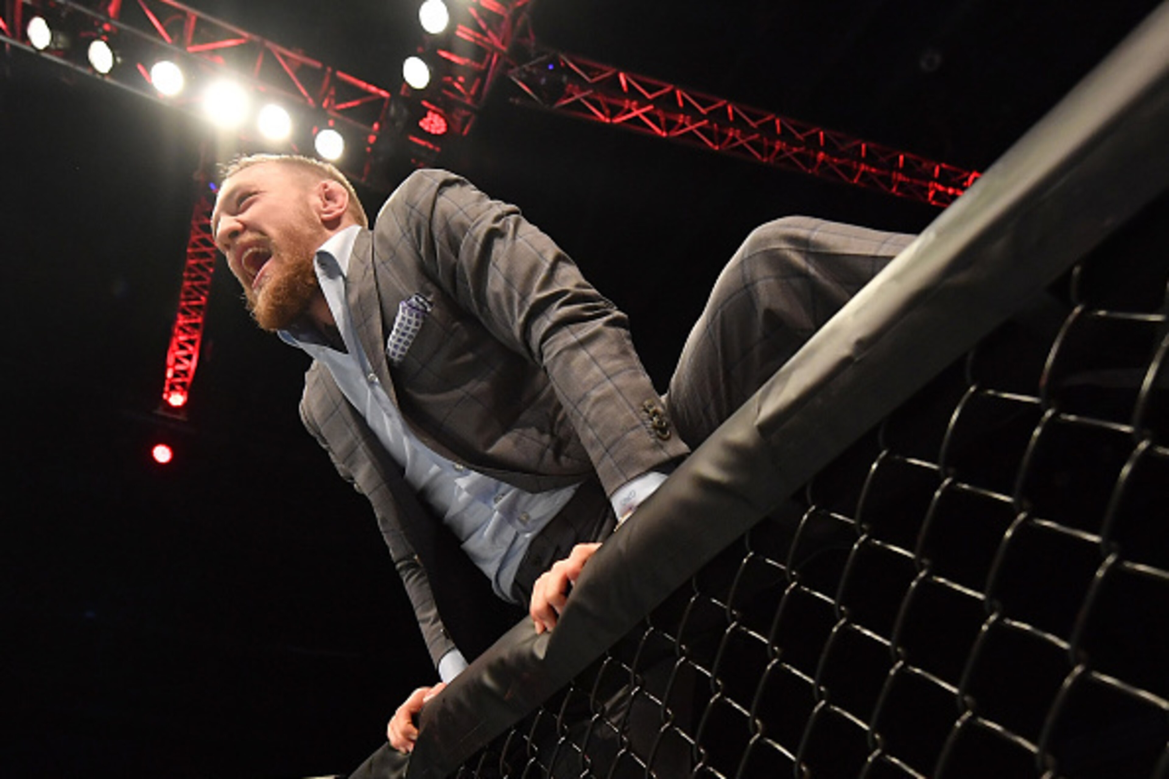 BELFAST, NORTHERN IRELAND - NOVEMBER 19:  UFC lightweight and featherweight champion Conor McGregor climbs into the Octagon to celebrate with teammate Artem Lobov after his featherweight bout against Teruto Ishihara during the UFC Fight Night at the SSE A