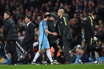 Manchester City's Spanish manager Pep Guardiola (CR) greets Manchester City's German midfielder Ilkay Gundogan (CL) as hee is substituted during the English Premier League football match between Manchester City and Watford at the Etihad Stadium in Manches