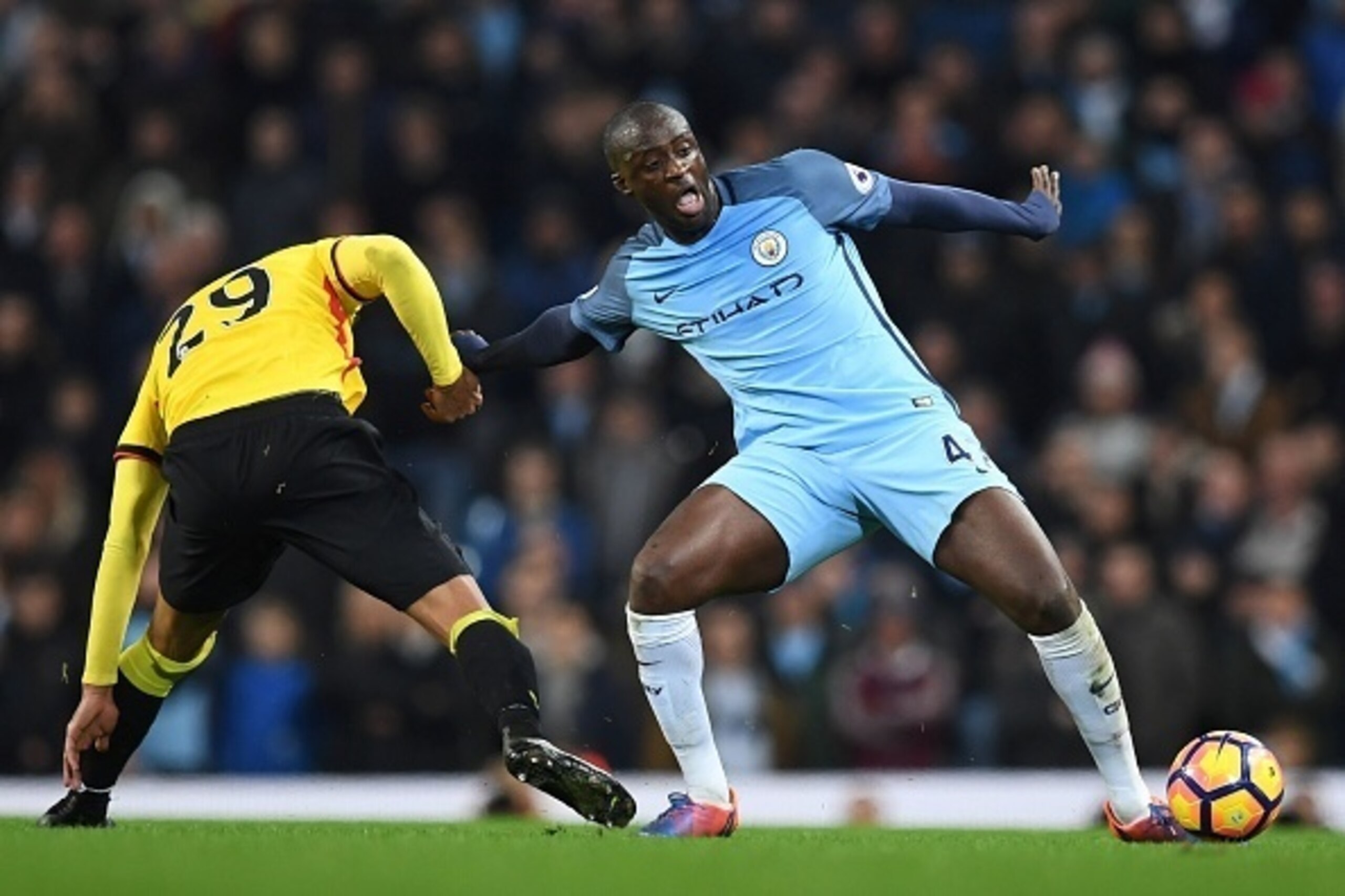 Manchester City's Ivorian midfielder Yaya Toure (R) and Watford's French midfielder Etienne Capoue (L) battle for the ball during the English Premier League football match between Manchester City and Watford at the Etihad Stadium in Manchester, north west