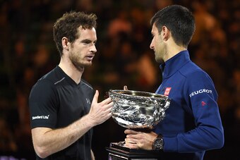Serbia's Novak Djokovic (R) shakes hands as he holds The Norman Brookes Trophy after victory in his men's singles final match against Britain's Andy Murray on day fourteen of the 2016 Australian Open tennis tournament in Melbourne on January 31, 2016.   A