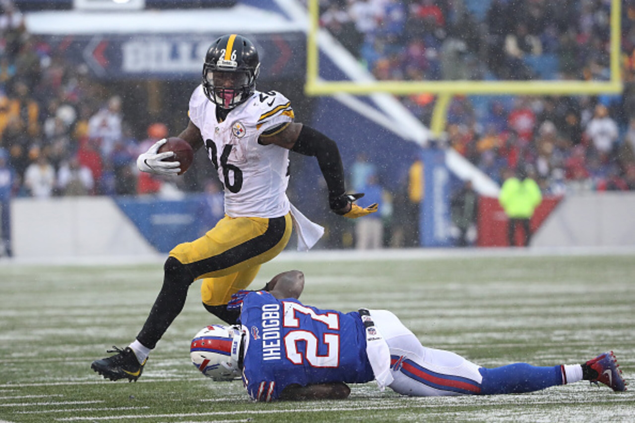 ORCHARD PARK, NY - DECEMBER 11: Le'Veon Bell #26 of the Pittsburgh Steelers runs after breaking an attempted tackle by James Ihedigbo #27 of the Buffalo Bills during NFL game action at New Era Field on December 11, 2016 in Orchard Park, New York. (Photo b