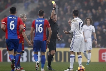 Chelsea's Brazilian-born Spanish striker Diego Costa (2R) gestures as English referee Jon Moss (C) shows him a yellow card for his challenge on Crystal Palace's Welsh midfielder Joe Ledley (3L) during the English Premier League football match between Crys