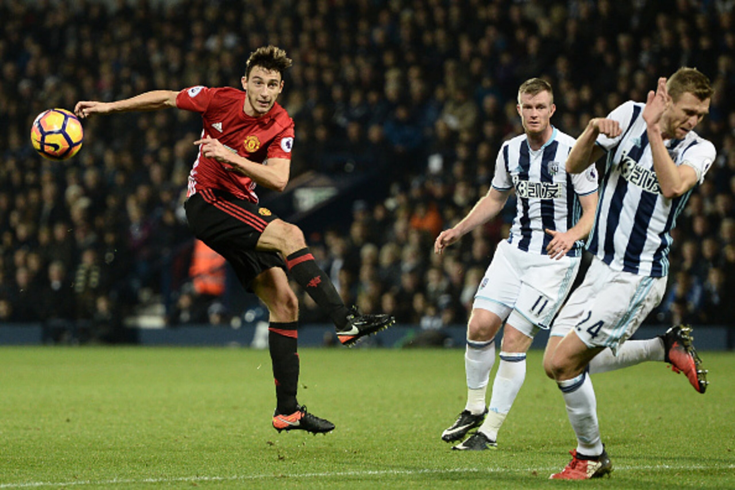 Manchester United's Italian defender Matteo Darmian (L) has an unsuccessful shot during the English Premier League football match between West Bromwich Albion and Manchester United at The Hawthorns stadium in West Bromwich, central England, on December 17