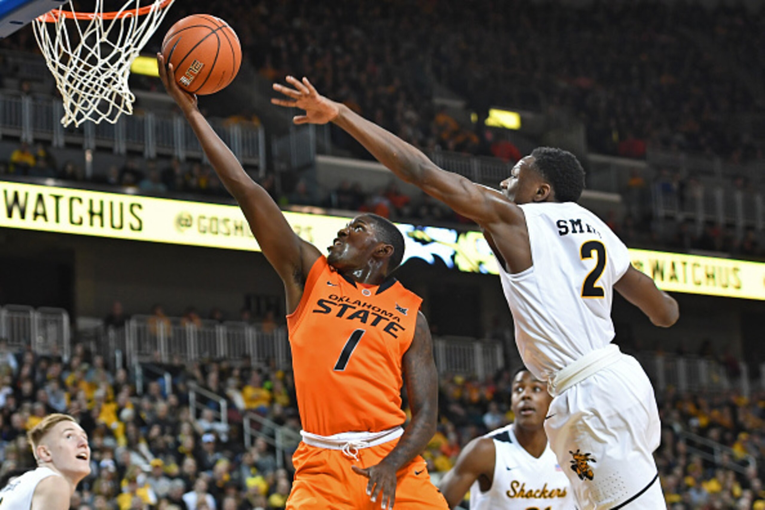 WICHITA, KS - DECEMBER 17:  Guard Jawun Evans #1 of the Oklahoma State Cowboys drives and scores past guard Daishon Smith #2 of the Wichita State Shockers during the first half on December 17, 2016 at INTRUST Bank Arena in Wichita, Kansas.  (Photo by Pete