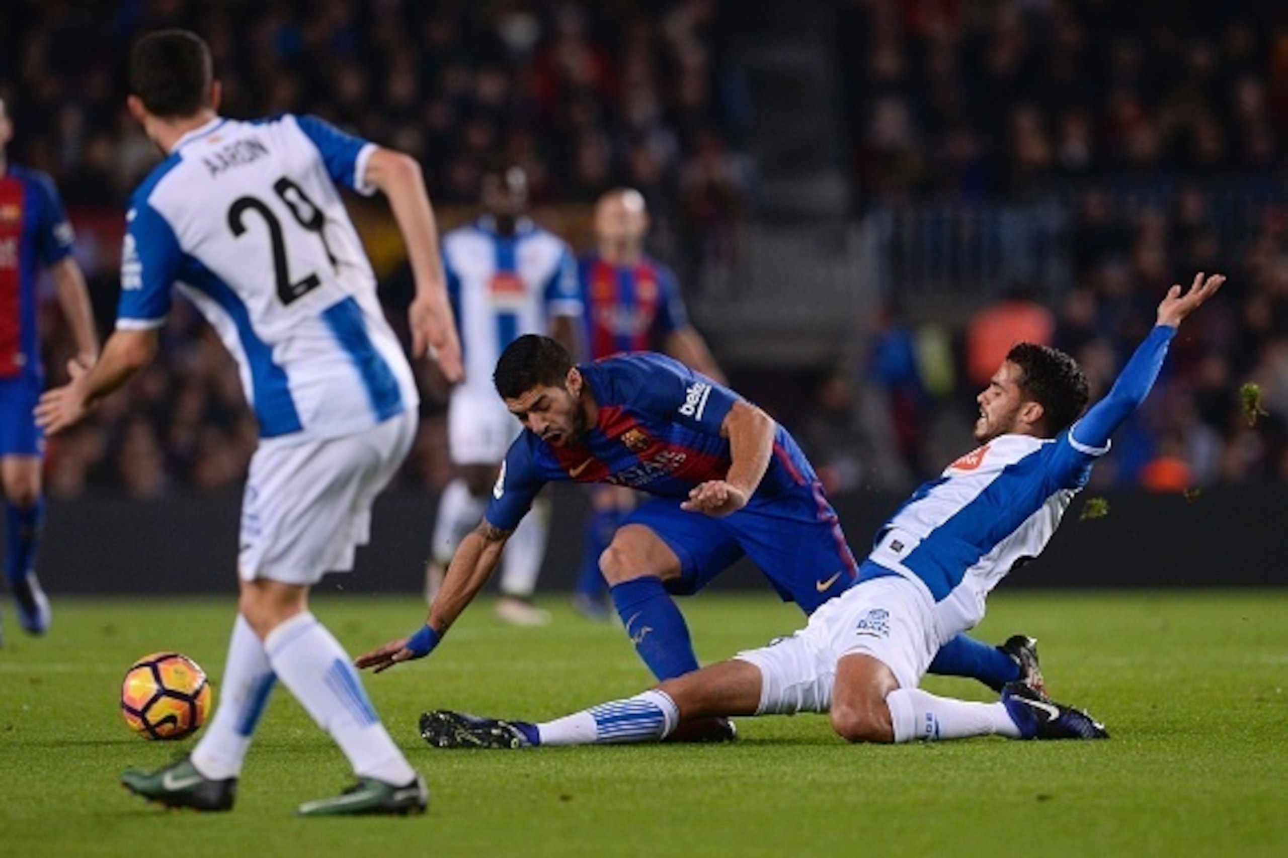 Barcelona's Uruguayan forward Luis Suarez (C) vies with Espanyol's defender Diego Reyes (R) during the Spanish league football match FC Barcelona vs RCD Espanyol at the Camp Nou stadium in Barcelona on December 18, 2016. / AFP / JOSEP LAGO        (Photo c