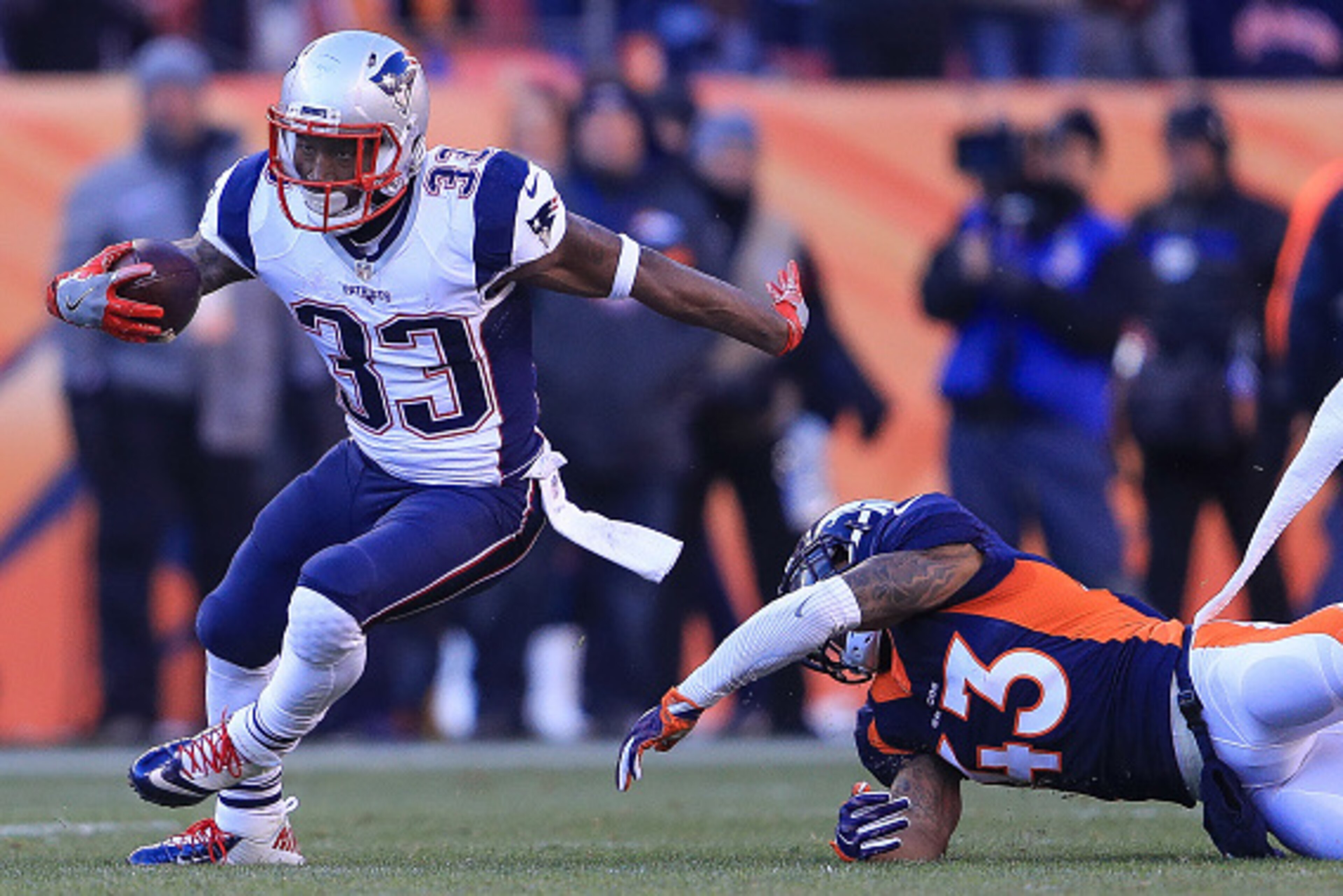 DENVER, CO - DECEMBER 18: Running back Dion Lewis #33 of the New England Patriots breaks away from a tackle attempt by strong safety T.J. Ward #43 of the Denver Broncos in the second quarter of a game at Sports Authority Field at Mile High on December 18 DENVER, CO - DECEMBER 18: Running back Dion Lewis #33 of the New England Patriots breaks away from a tackle attempt by strong safety T.J. Ward #43 of the Denver Broncos in the second quarter of a game at Sports Authority Field at Mile High on December 18