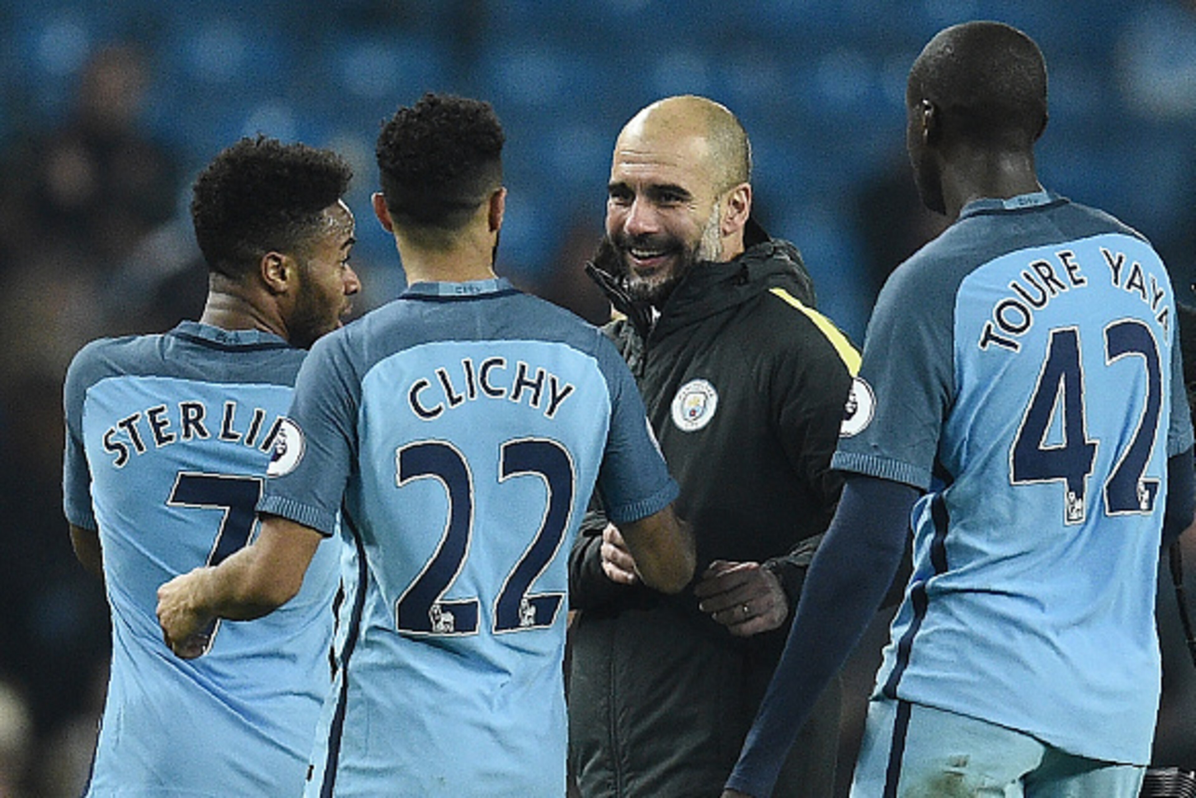 Manchester City's Spanish manager Pep Guardiola (C) congratulates Manchester City's English midfielder Raheem Sterling (L) Manchester City's French defender Gael Clichy (2L) and Manchester City's Ivorian midfielder Yaya Toure following the English Premier