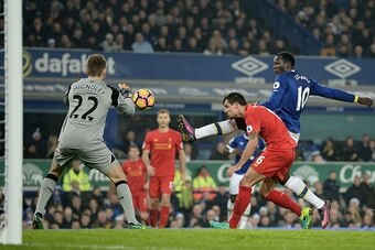 Everton's Belgian striker Romelu Lukaku (R) vies with Liverpool's Belgian goalkeeper Simon Mignolet (L) and Liverpool's Croatian defender Dejan Lovren during the English Premier League football match between Everton and Liverpool at Goodison Park in Liver