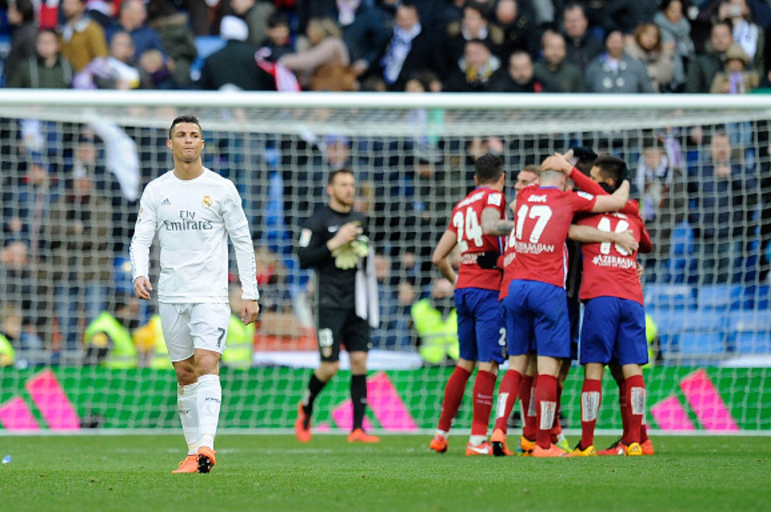 MADRID, SPAIN - FEBRUARY 27:  Cristiano Ronaldo of Real Madrid walks away from celebrating Atletico Madrid players after Atletico beat Real 1-0 in the La Liga match between Real Madrid CF and Club Atletico de Madrid at Estadio Santiago Bernabeu on Februar