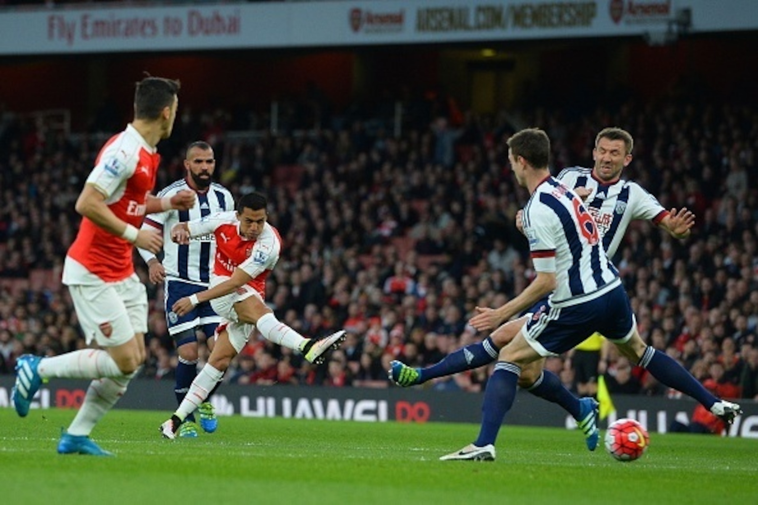 Arsenal's Chilean striker Alexis Sanchez (3L) scores the opening goal during the English Premier League football match between Arsenal and West Bromwich Albion at the Emirates Stadium in London on April 21, 2016.  / AFP / GLYN KIRK / RESTRICTED TO EDITORI