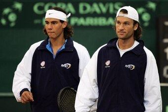 SEVILLE, SPAIN - DECEMBER 2:  Carlos Moya and Rafael Nadal of Spain walk out for practice for the Davis Cup by BNP Paribas-World Group Final between Spain and United States of America at the Estadio Olimpico de Sevilla on December 2, 2004 in Seville, Spai