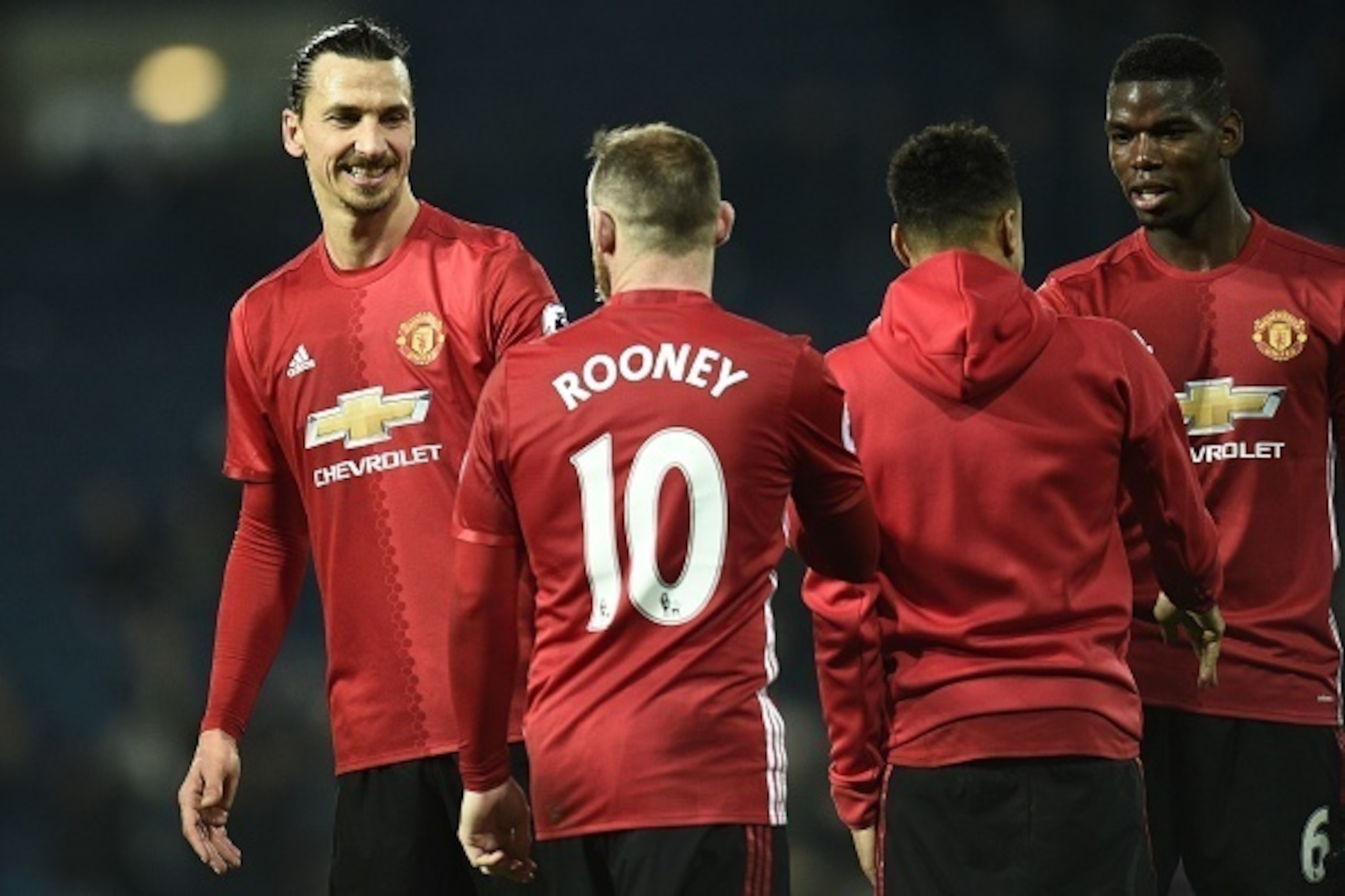Manchester United's Swedish striker Zlatan Ibrahimovic (L), Manchester United's English striker Wayne Rooney (2nd L), Manchester United's English midfielder Jesse Lingard and Manchester United's French midfielder Paul Pogba (R) celebrate on the pitch afte
