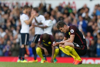 Manchester City's English defender John Stones reacts on the final whistle as Tottenham player celebrate behind after the English Premier League football match between Tottenham Hotspur and Manchester City at White Hart Lane in London, on October 2, 2016.