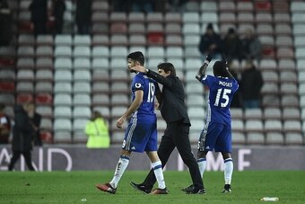 Chelsea's Italian head coach Antonio Conte (C) hugs Chelsea's Brazilian-born Spanish striker Diego Costa (L) as Chelsea's Nigerian midfielder Victor Moses applauds the fans following during the English Premier League football match between Sunderland and 